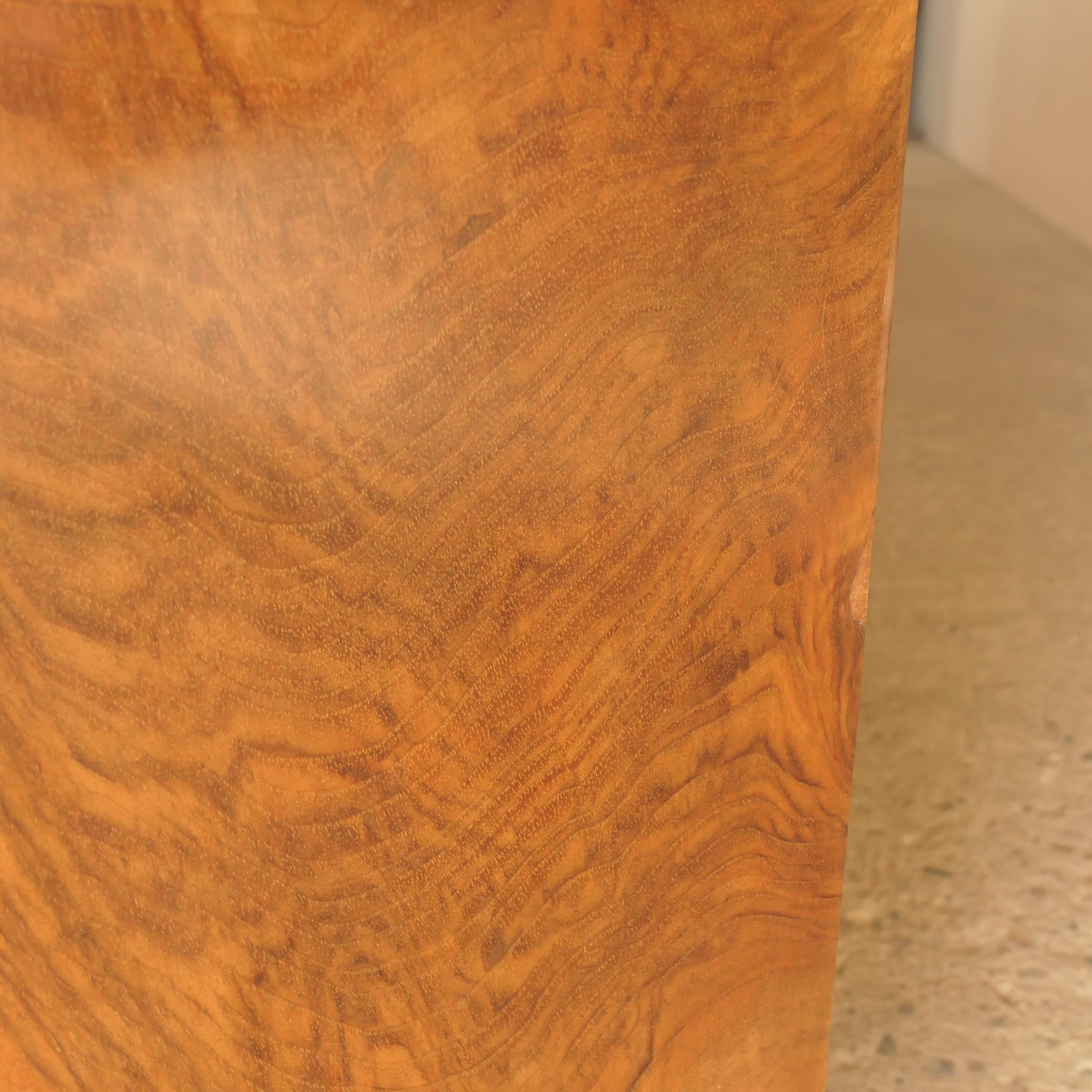 Elegant French sideboard dating from the 1940s, crafted with a solid hardwood frame and finished in richly patterned walnut burl veneer. The piece showcases exceptional craftsmanship, featuring intricate brass handles, decorative carved bun feet,