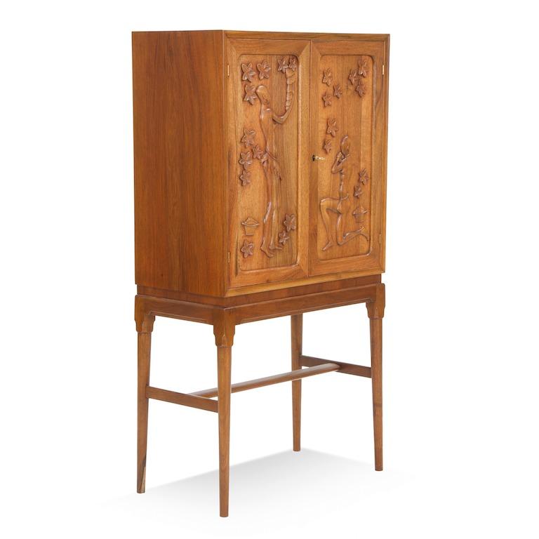 A fine walnut cabinet by Danish designer and artist Anton Kildeberg, the doors carved with
two female figures picking fruit, the interior fitted with two shelves, signed and marked 1949.
  