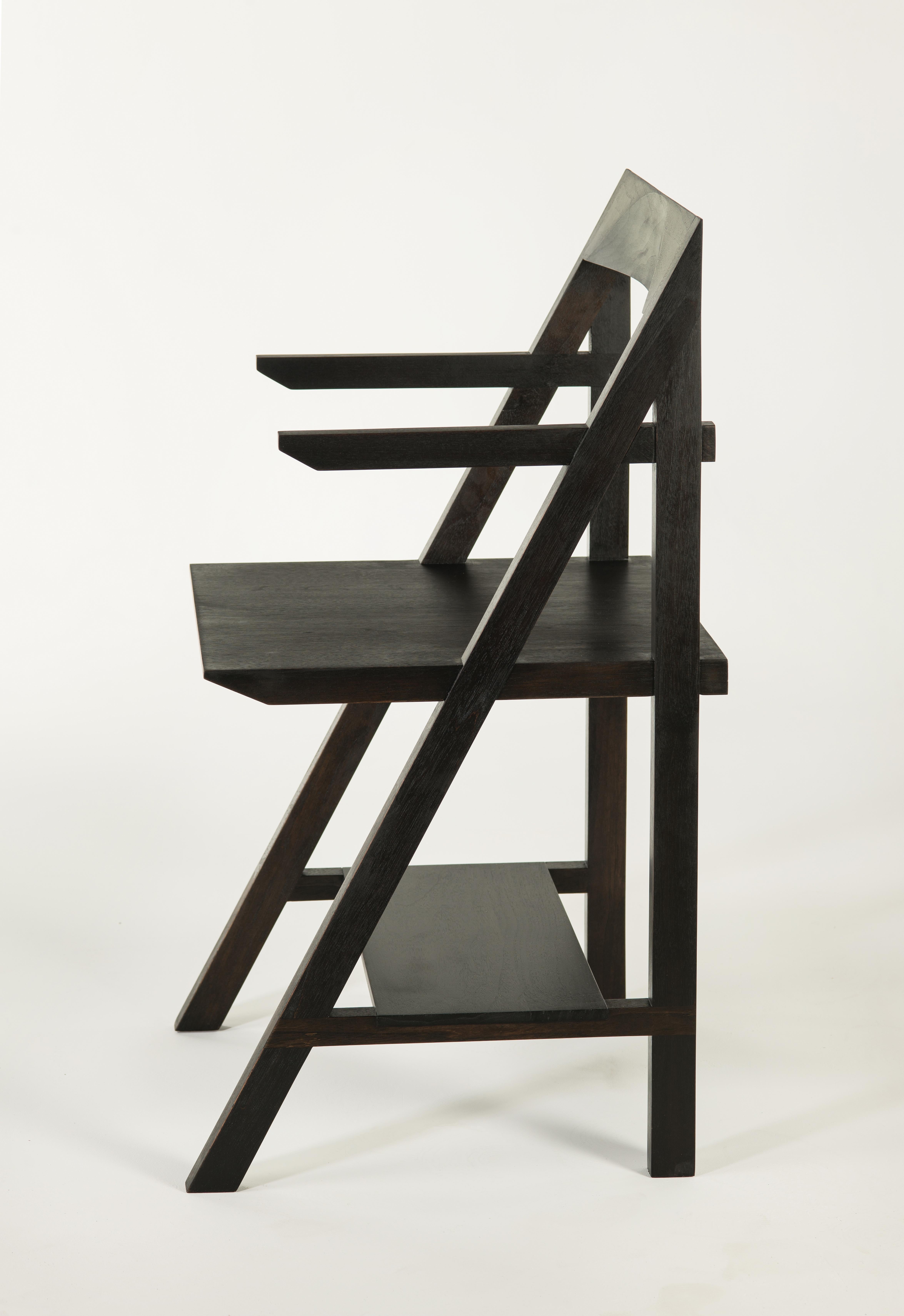 Walnut cantilever armchair by Phaedo.
Dimensions: H 35” x D 18-1/2” x W 20-3/4” inches.
Materials: oxidized black walnut. 

The Cantilever chair is a true blend of form and function, the shelf below provides a practical means of storage without