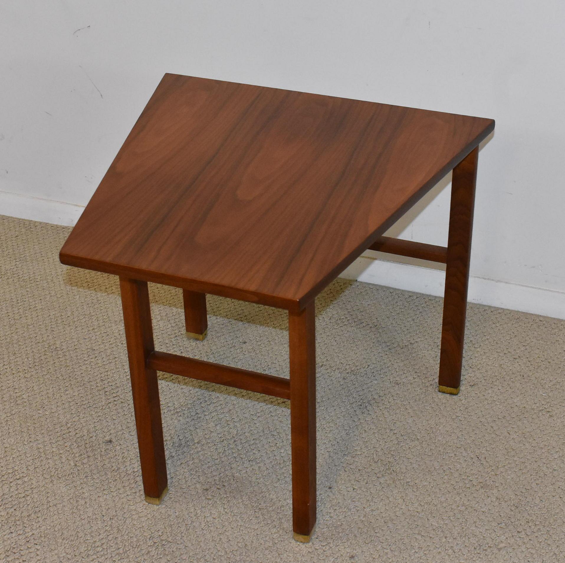 Walnut wedge table with a cantilever top designed by Edward Wormley for Dunbar. Table is done in beautiful oil finished walnut with great graining. Brass caps at feet add to design. Wonderful condition on this.