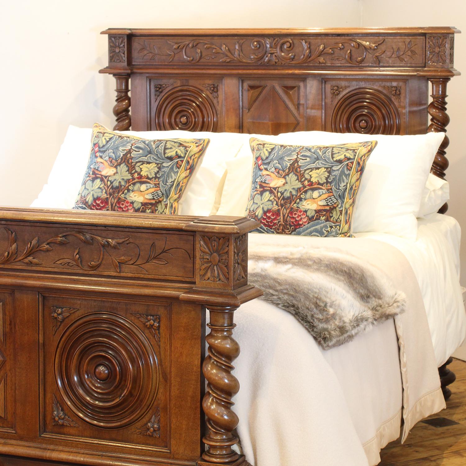 An impressive bedstead in walnut with decoratively carved panels, and turned barley twist posts.

This bed accepts a British king size or American queen size, 5ft wide (60 inches or 150cm) base and mattress set, with an overlap (as shown)

The