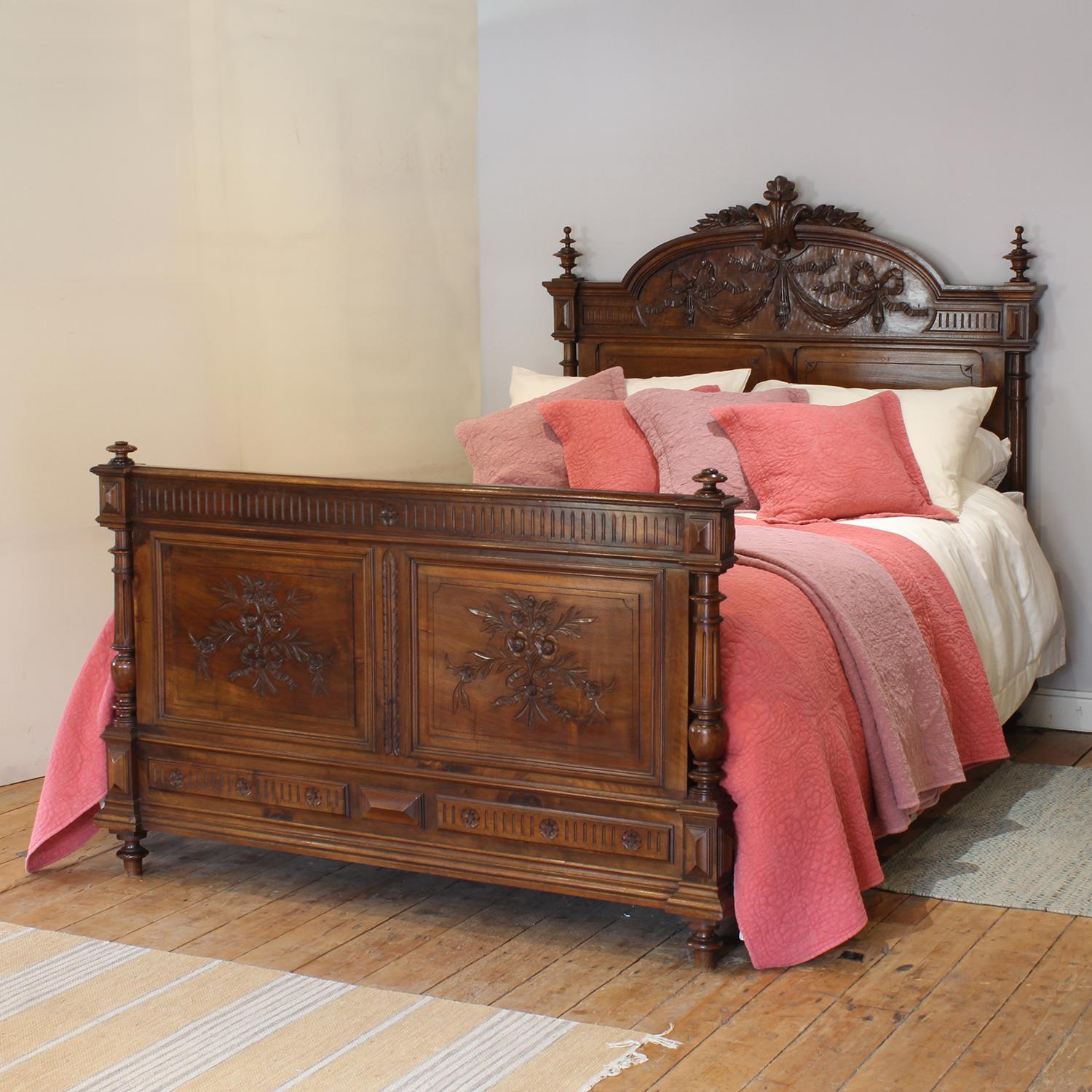 A fine French antique bed from the early Twentieth century, with decoratively carved panels on the foot board, turned posts and decorative pediment on the head end.

This bed accepts a US Queen Size (or UK King Size), 5ft wide (60 in), base and