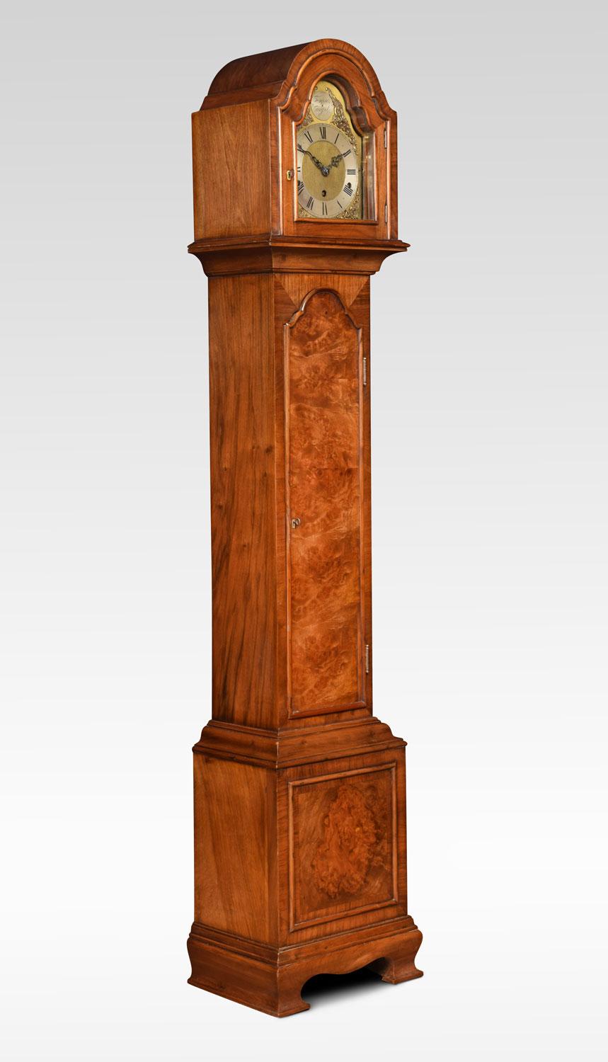 Walnut cased grandmother clock, the arched hood to the brass dial engraved with gilt-metal Roman numerals and decorated foliated face, with chime/silent leaver. The eight day spring driven movement chiming on gongs. The walnut case with long