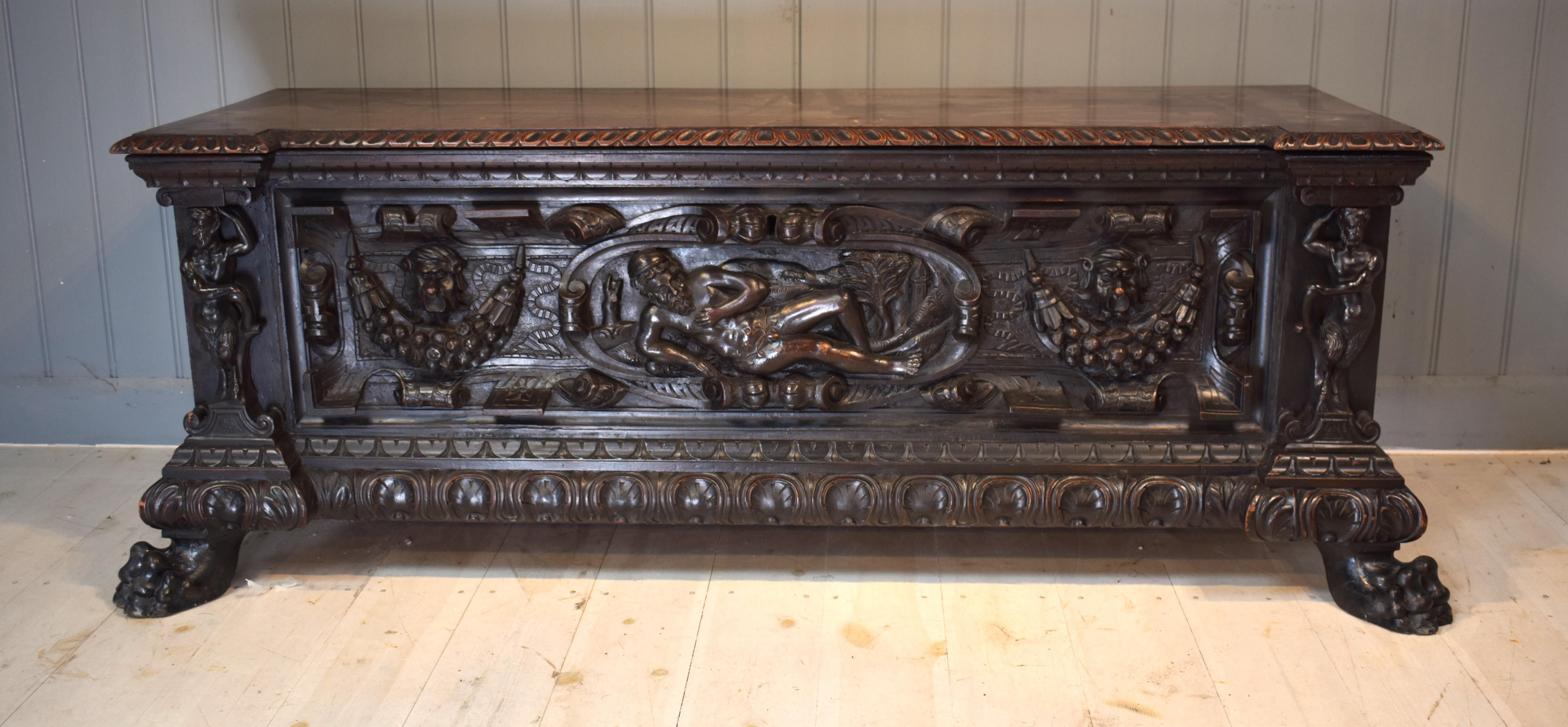 A lovely carved Italian cassone on hairy paw feet . It has an interesting carved front with a resting man and a pair of fauns.We believe the bearded gentleman is probably the god Silvanus the god of nature, and the fauns ( half man half goat )
