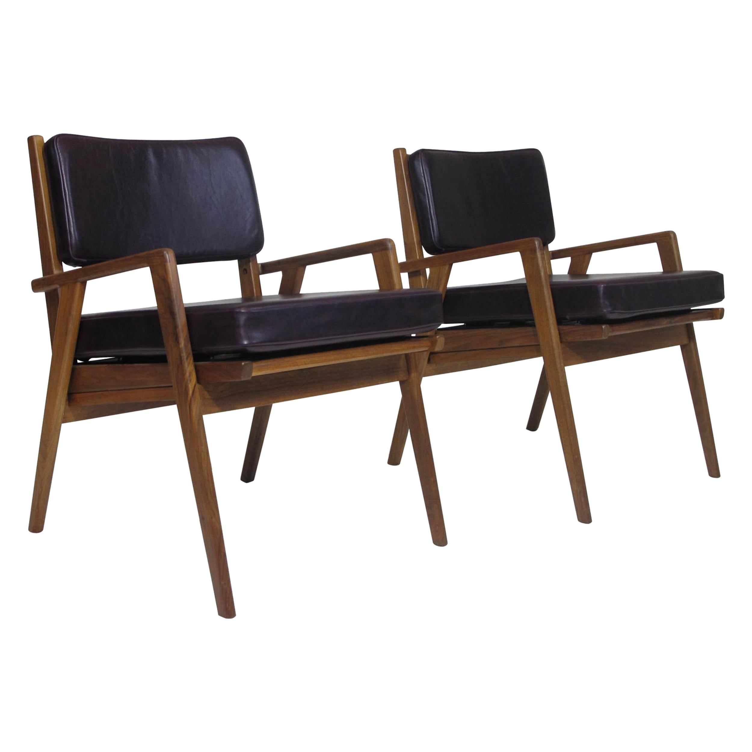 Pair of midcentury walnut lounge chairs attributed Jens Risom crafted of a solid black walnut frames with an angled arms. Newly upholstered cushions in a top-grain aubergine leather. Excellent condition.