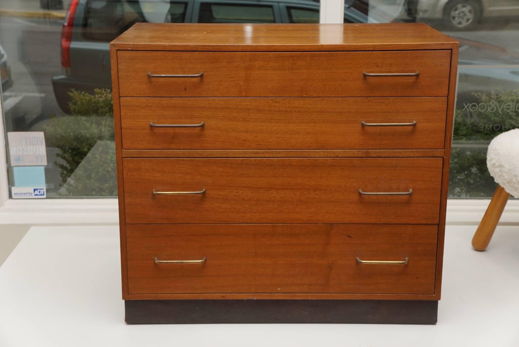 Midcentury, walnut chest of drawers, designed by Edward Wormley for Dunbar this handsome chest has four drawers with simple, solid brass pulls, and rests on a base, that is wrapped in chocolate brown leather. The top drawer has four, unique sections