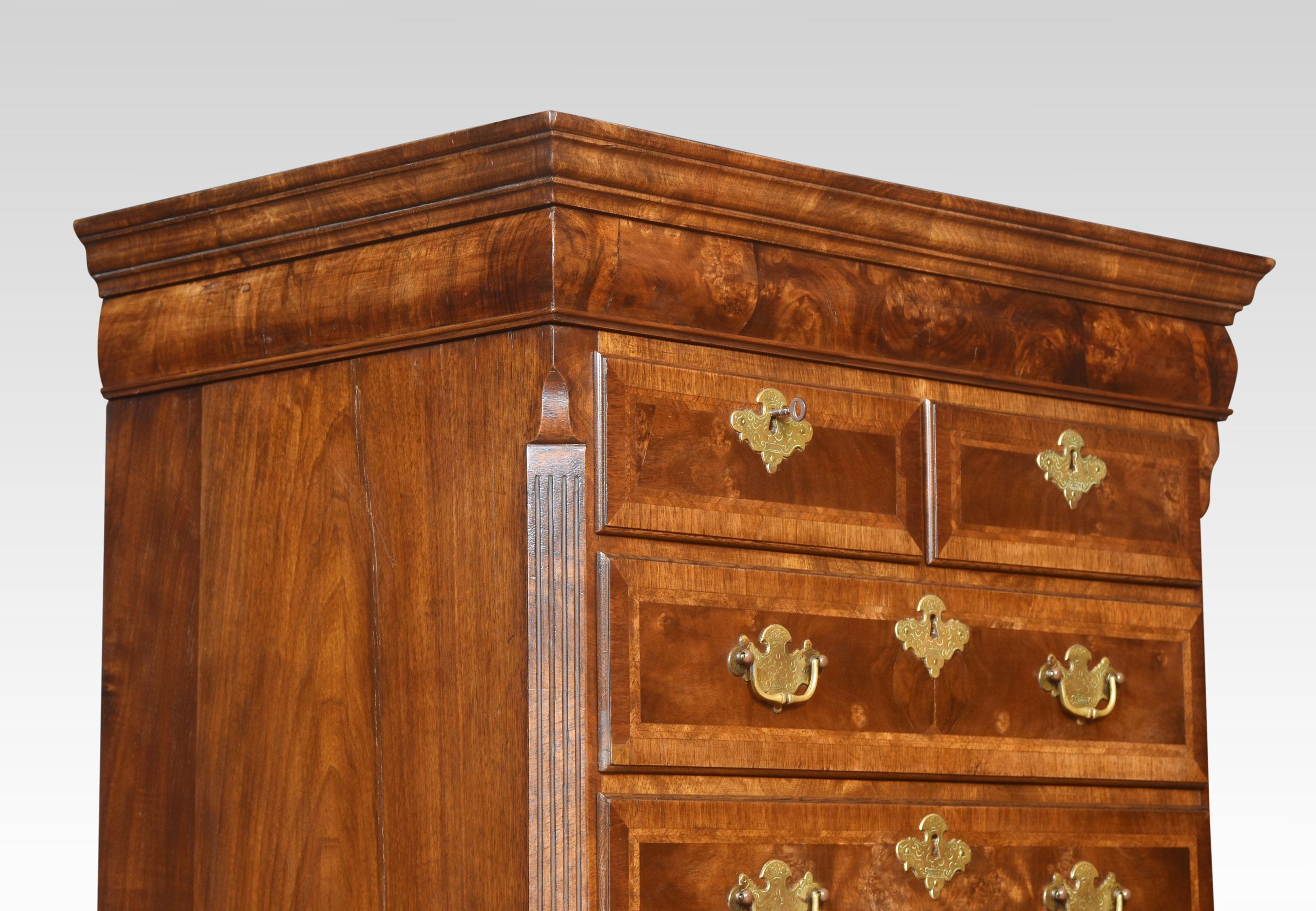 Walnut chest on chest, of slender proportions, the moulded top above two short and three long graduated drawers. The base fitted with three long graduated drawers all having oak drawer liners, crossbanding and brass tooled handles raised up on bun