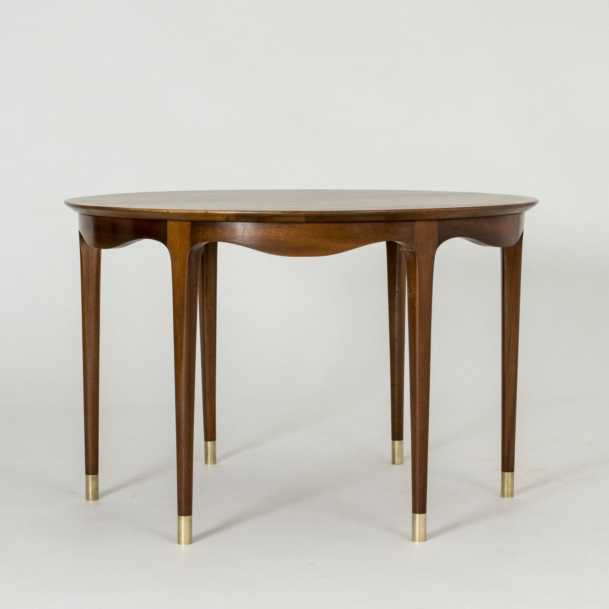 Stunning walnut coffee table by Ole Wanscher, with a beautiful wavy rim and brass feet on the six legs.