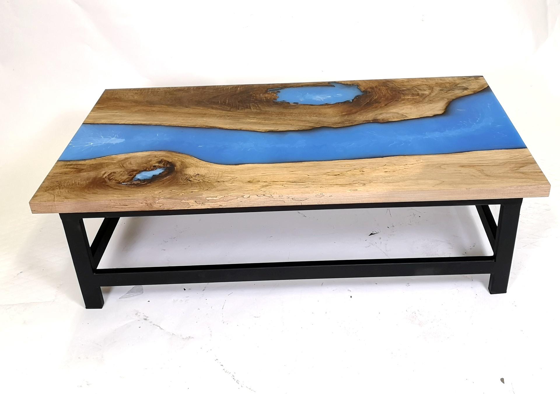 The coffee table was made in Hungary with walnut wood. The wood is kilned and dried prior to being filled with high quality resin and has steel legs.