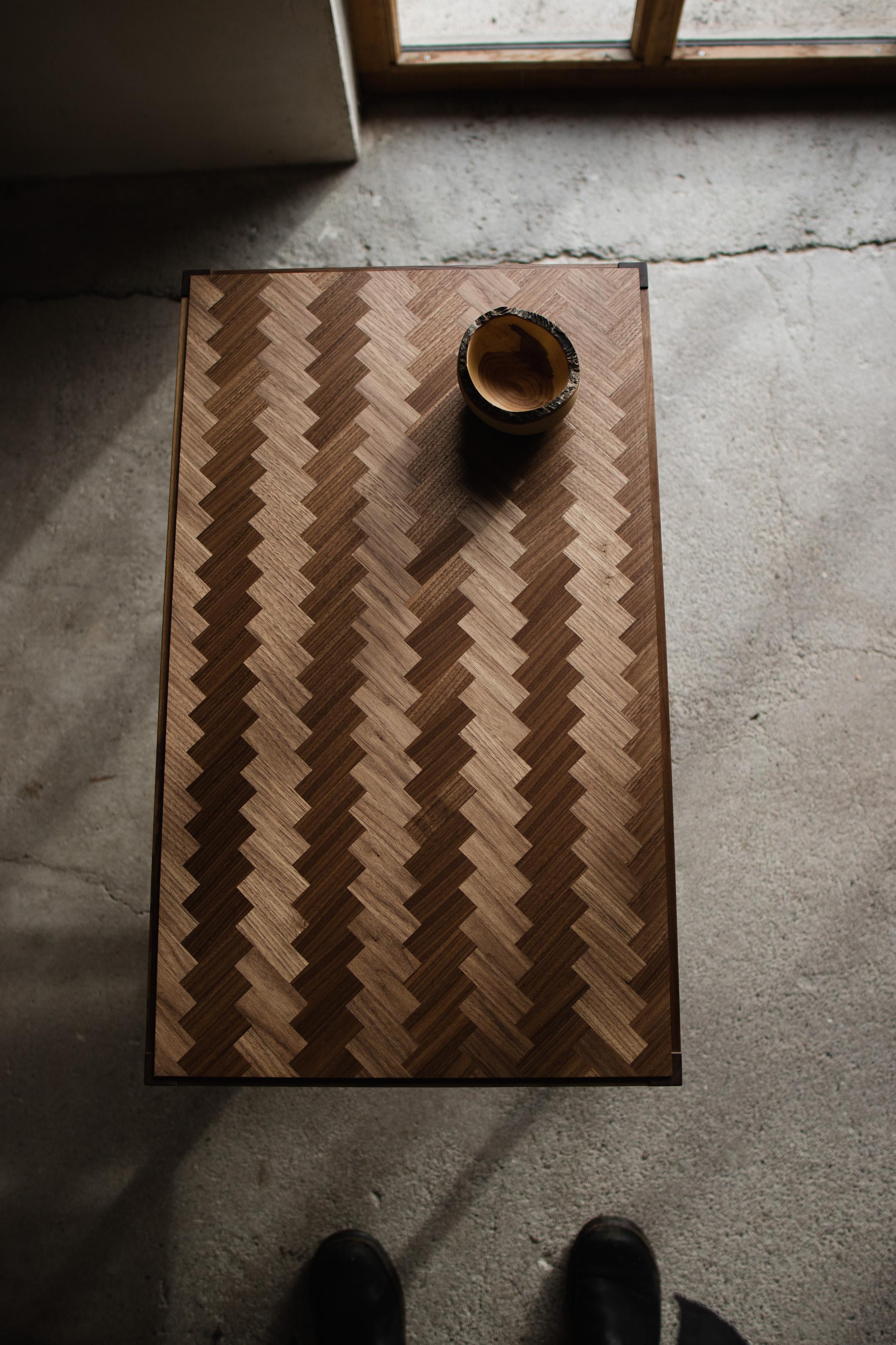 Tavolino da caffè in noce con design a spina di pesce

Questo tavolino presenta un piano in parquet a spina di pesce che mette in risalto la bellezza naturale del legno. La base è in noce massiccio, costruita con i tradizionali incastri a mortasa e