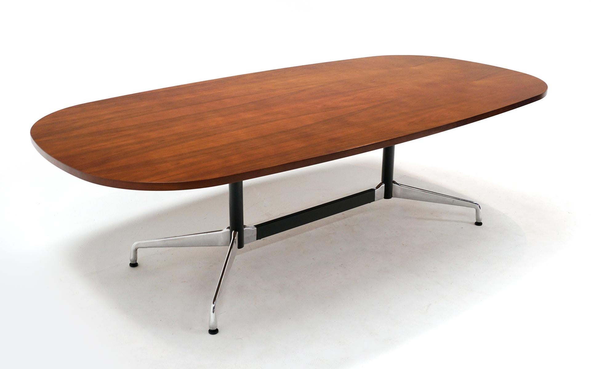 Eight foot long walnut dining / conference table designed by Charles and Ray Eames, manufactured by Herman Miller. Signed with the Eames Herman Miller label. This table was produced in the 2000s and is in very good condition with only a few light