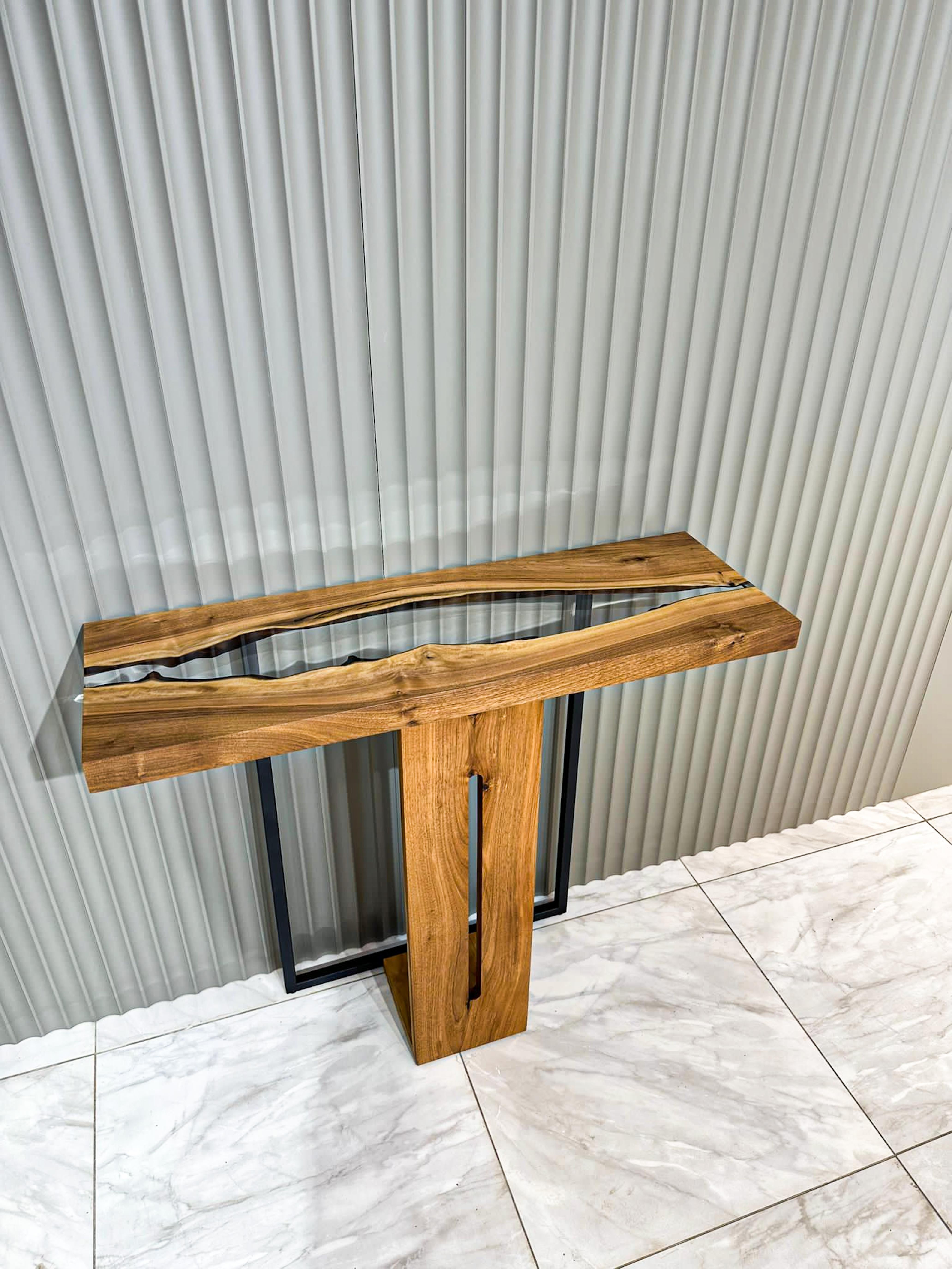 Walnut Wood Epoxy Console Table

Presenting our Epoxy Waterfall ConsoleTable – a true sample of craftsmanship and elegance. This exceptional piece of furniture is designed to be more than just a coffee table; it's a statement of refined taste and