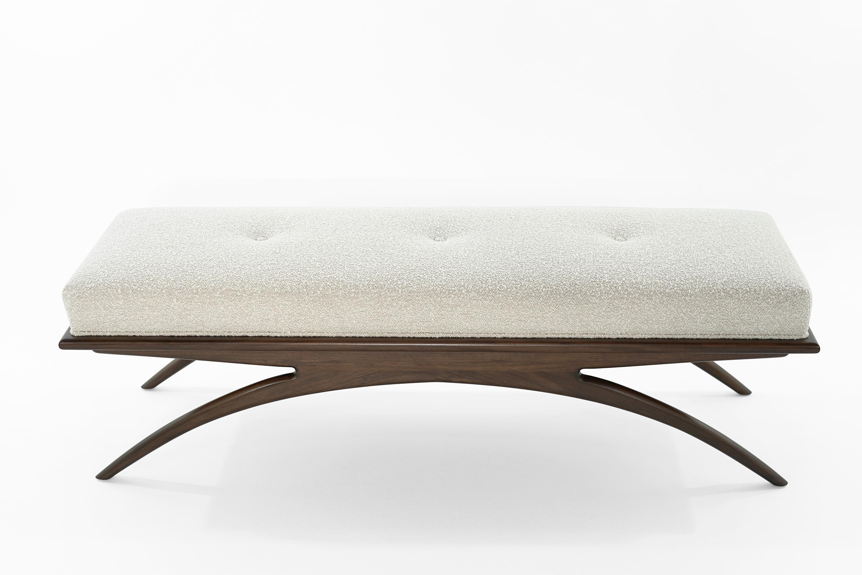 Artfully balanced. This handcrafted bench has a lightweight aesthetic with solid construction. The prim, rectangular cushion is beautifully upholstered in soft bouclé, resting delicately on a solid walnut base. Elevate your space with sloping curves