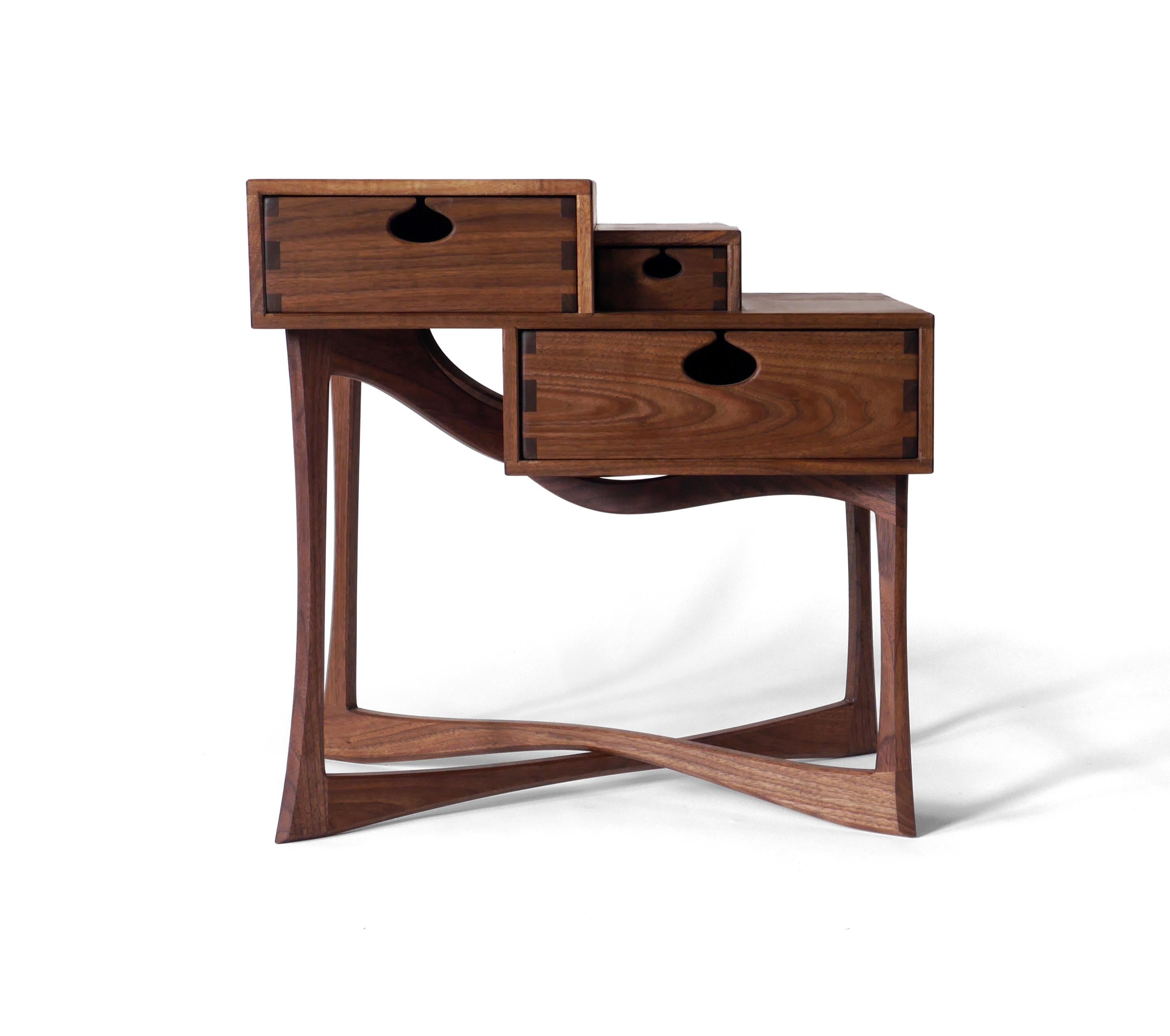 The charismatic Coriolis side table is made out of solid black walnut hardwood and has three drawers mounted on wooden runners in traditional drawer boxes. It’s built with exposed joinery that has been carefully designed for beauty and strength.