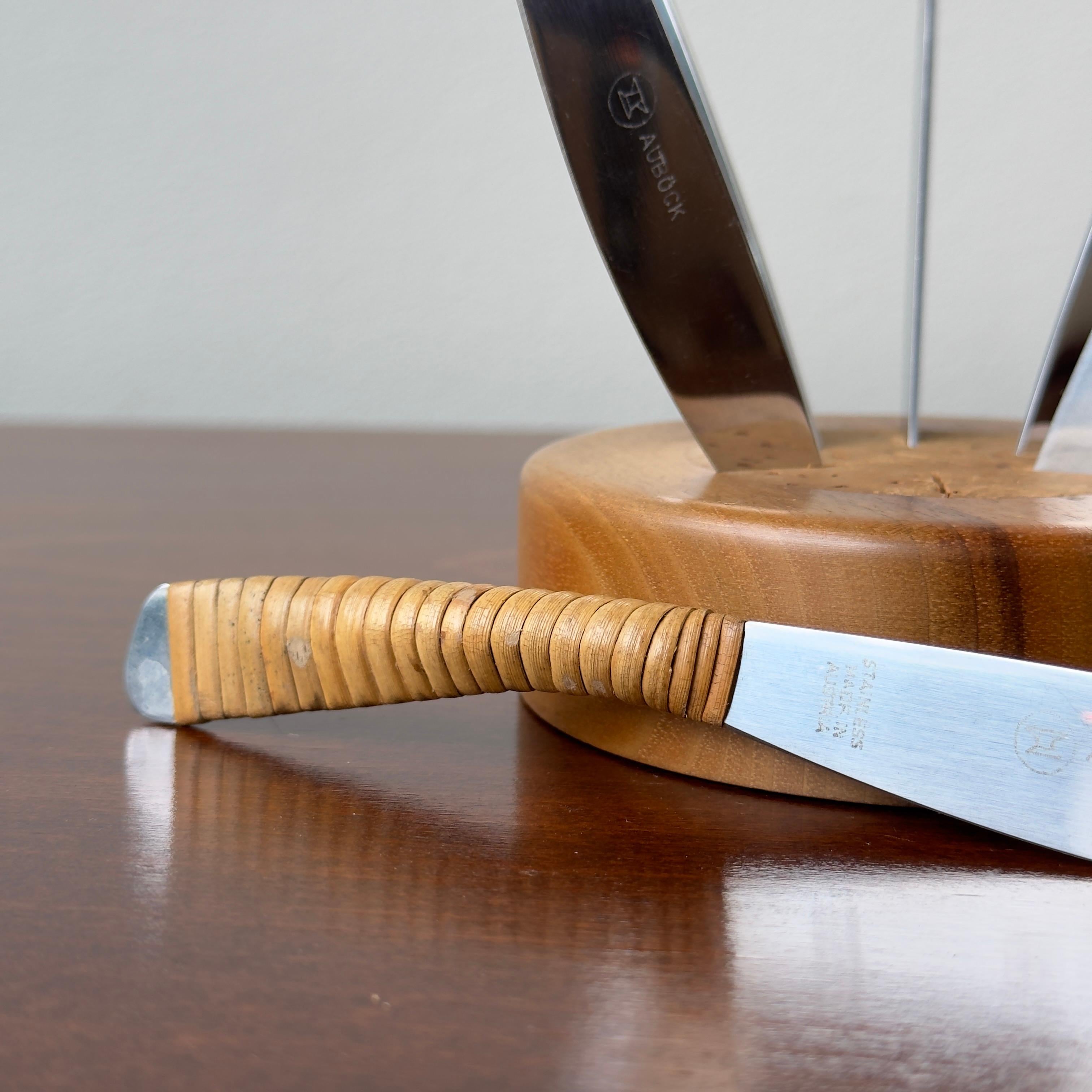 A set of 6 cane wrapped fruit knives with a walnut stand and cork insert, designed by Carl Auböck II during the 1950s. 

With a round walnut base with cork insert for the six cane wrapped knives, this fruit knife set is testament to the