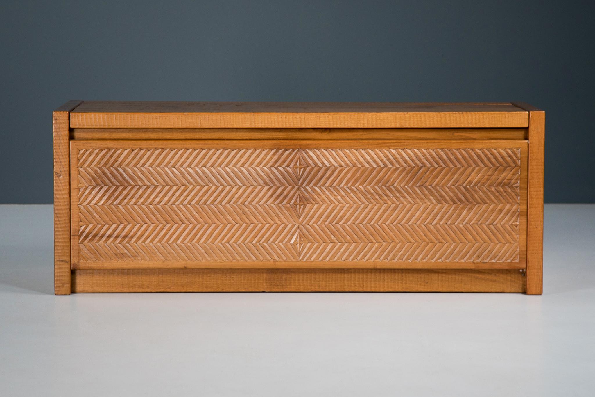 A very elegant blanket chests hand carved out of Italian walnut wood and hand-finished in full relief with a gouge designed by Giuseppe Rivadossi in the late 1970s. The architonic style creates emphasis on the apparent structure. Rivadossi furniture