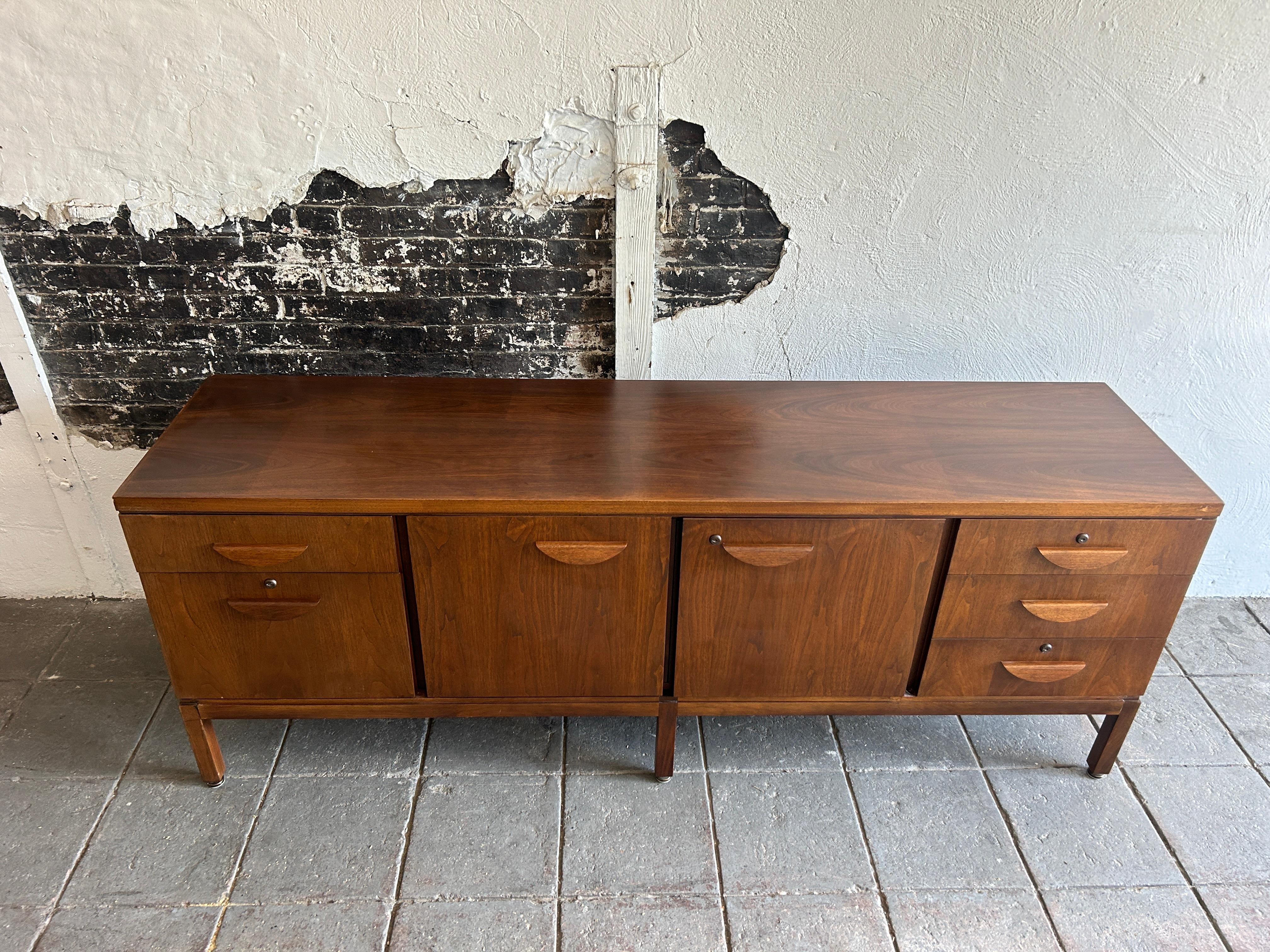 Beautiful walnut mid century office credenza fully locking. Has 5 drawers and 2 center cabinet doors with 1 adjustable shelf. Sits on 6 square legs with adjustable leveling feet/glides. Very clean all around. Great for home or office. Very nice