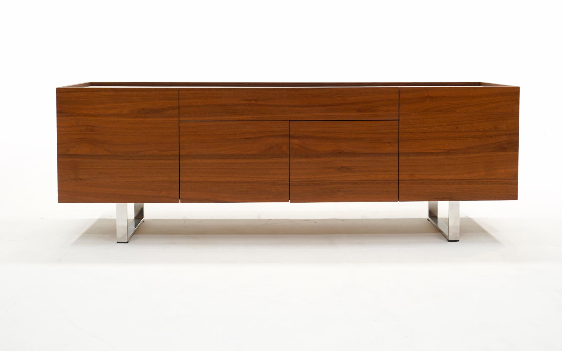 Walnut credenza / sideboard / buffet / media cabinet by Calligaris, Italy.  The black glass top is attached and inset 1/2 inch.  The center doors open to reveal a large storage space while the side doors reveal an adjustable glass shelf.  The large