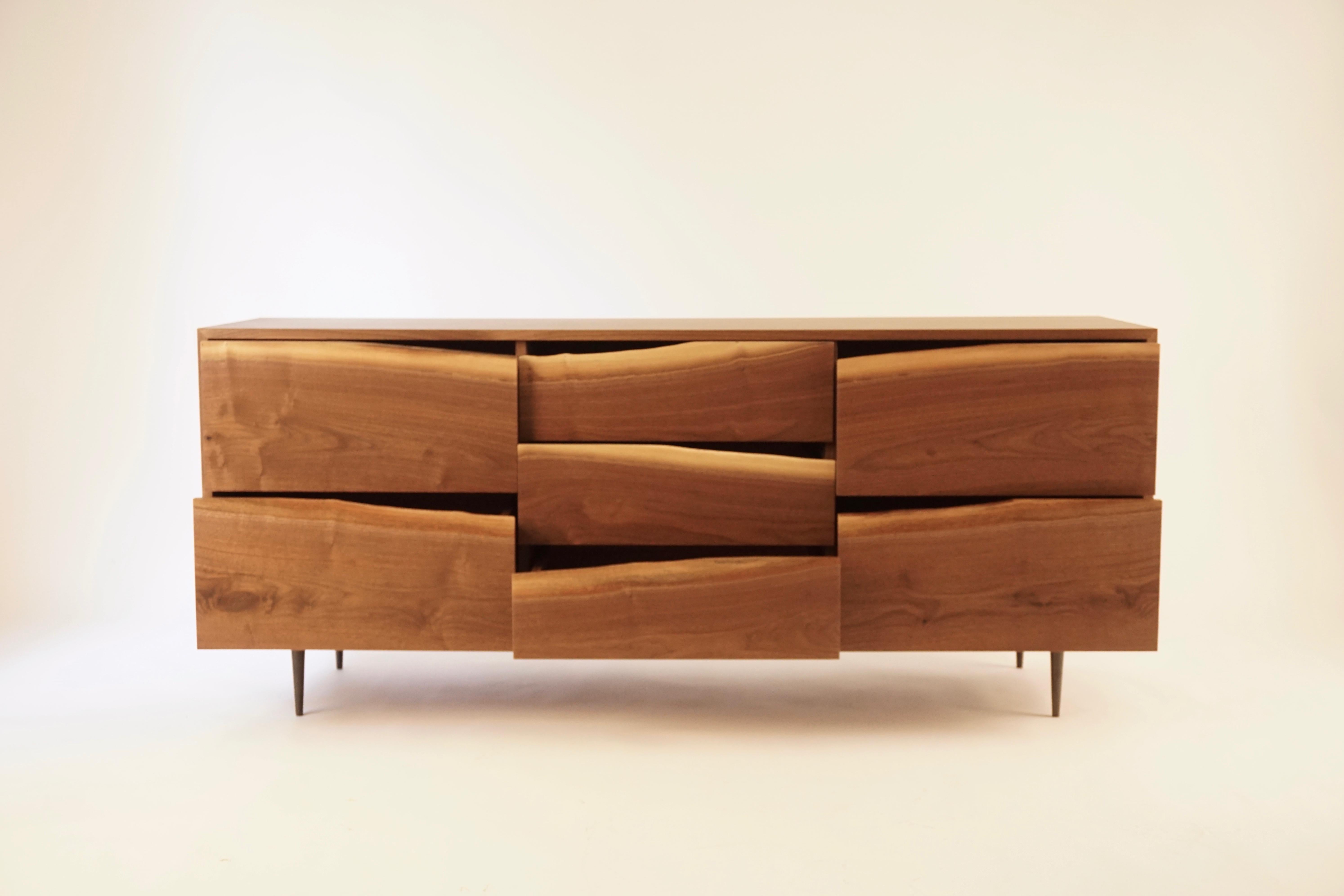 This credenza is from a collection of cabinets that emphasize the organic shape of the tree as a functional handle for the drawer faces. Each piece made from boards of the same tree, as they appear after milling. The bases are made from solid