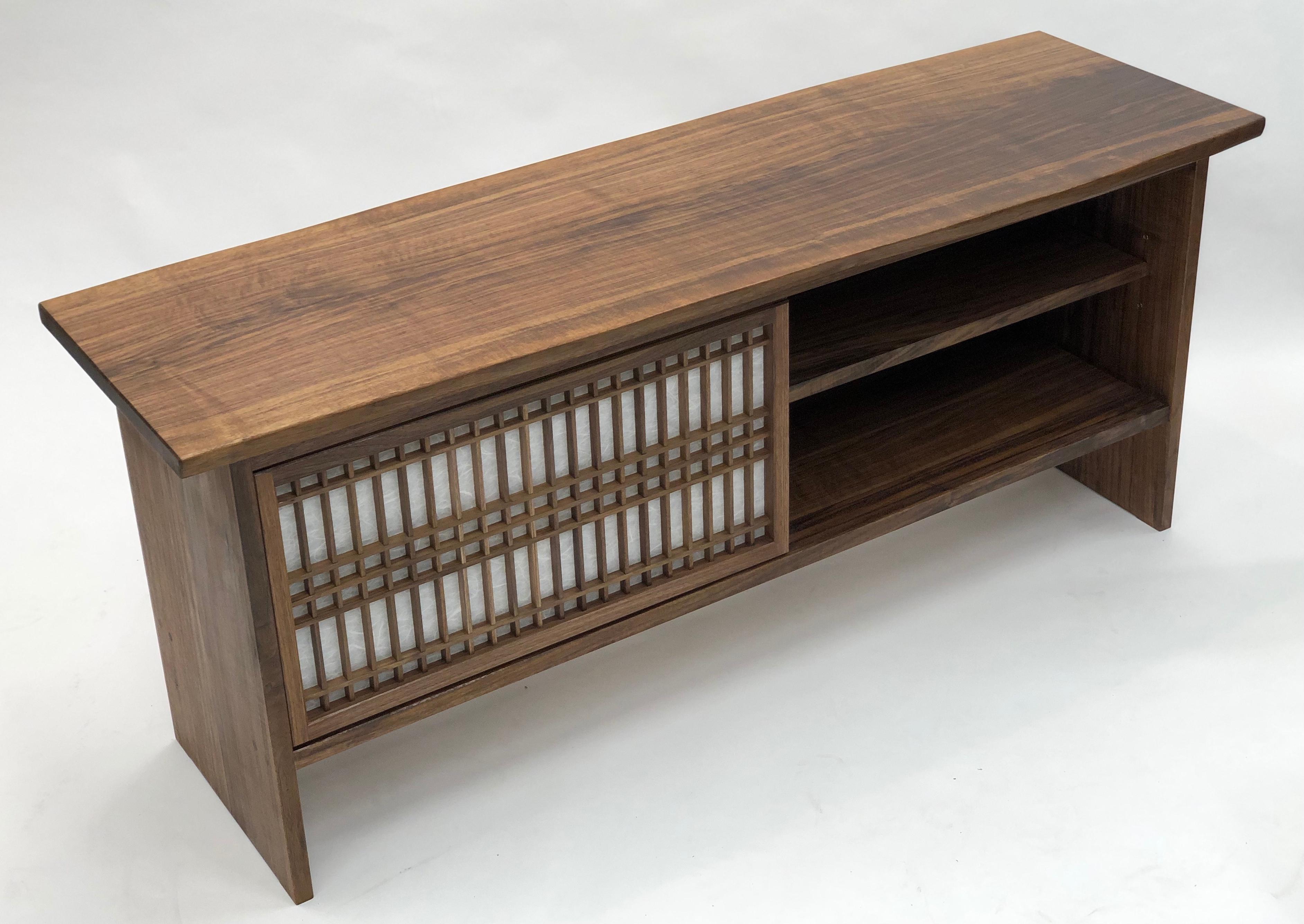 Walnut credenza made by hand and featuring sliding shoji doors and a shelf. This cabinet is constructed utilizing time honored joinery techniques featured in Japanese temple carpentry in addition it features shoji made utilizing those same