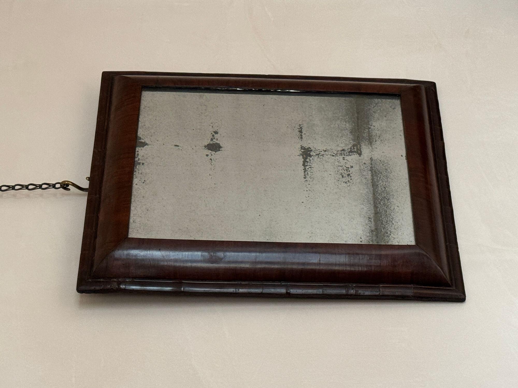 A late 17th / 18th Century English walnut cushion framed mirror.
With a beautifully aged plate.
H: 64 cm (25 3/16