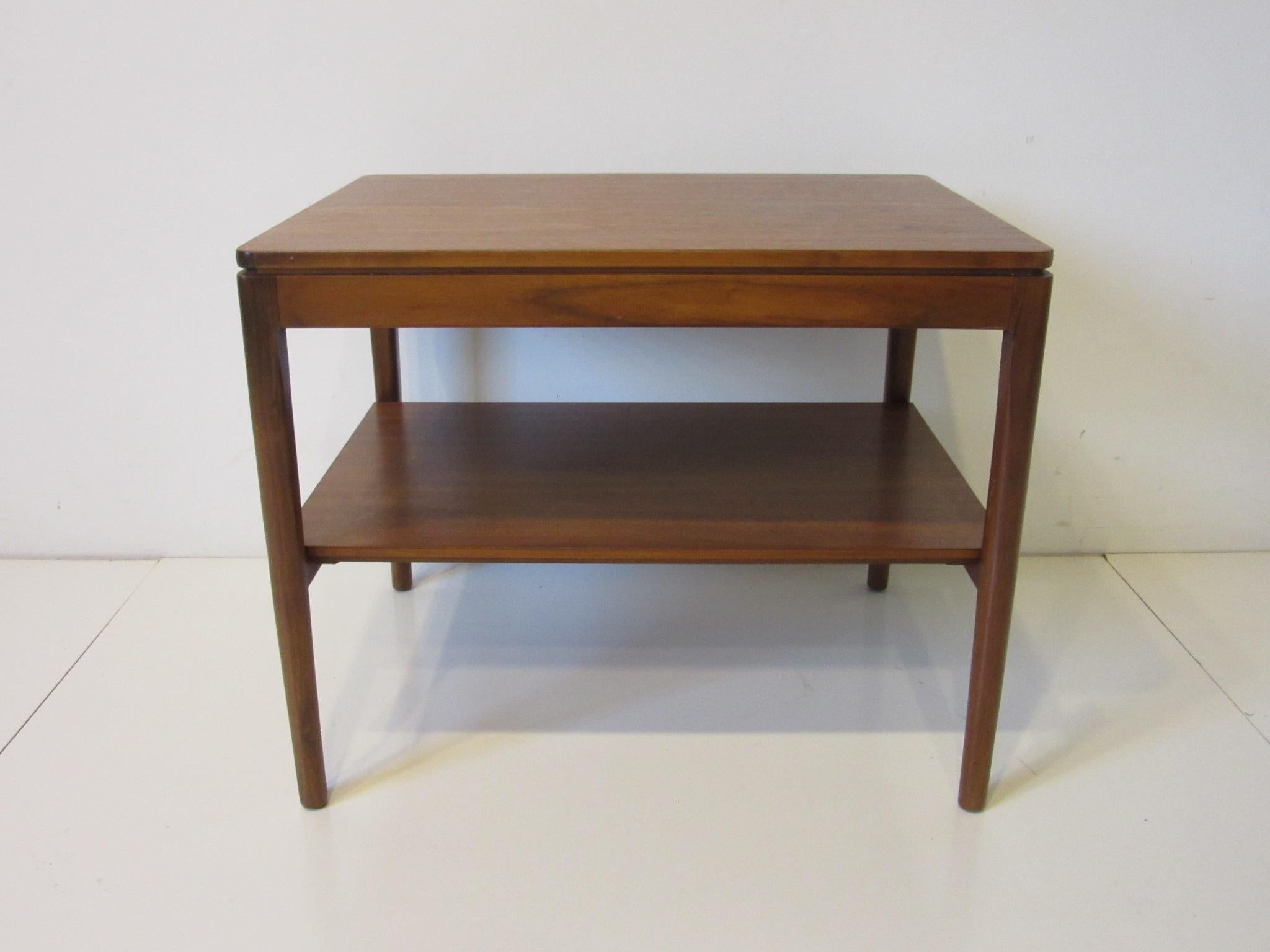 A walnut side table with solid construction designed by Kipp Stewart for Drexel from their Declaration collection, a simple design with rounded edges and fine wood gaining. Retains the manufactures stenciled model and manufactures information.