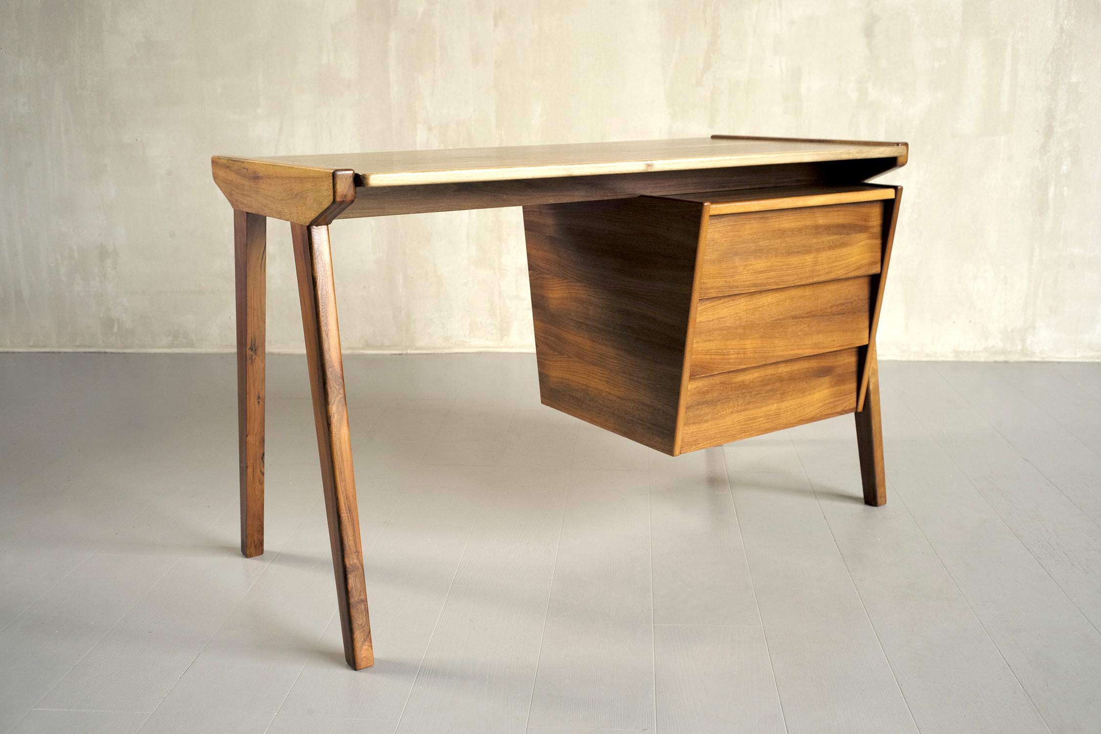 Box desk in blond walnut, 1960. The portico-shaped base receives a pyramidal box with three cutaway drawers. The line and the realization give this desk a special charm and elegance.
Very good condition.