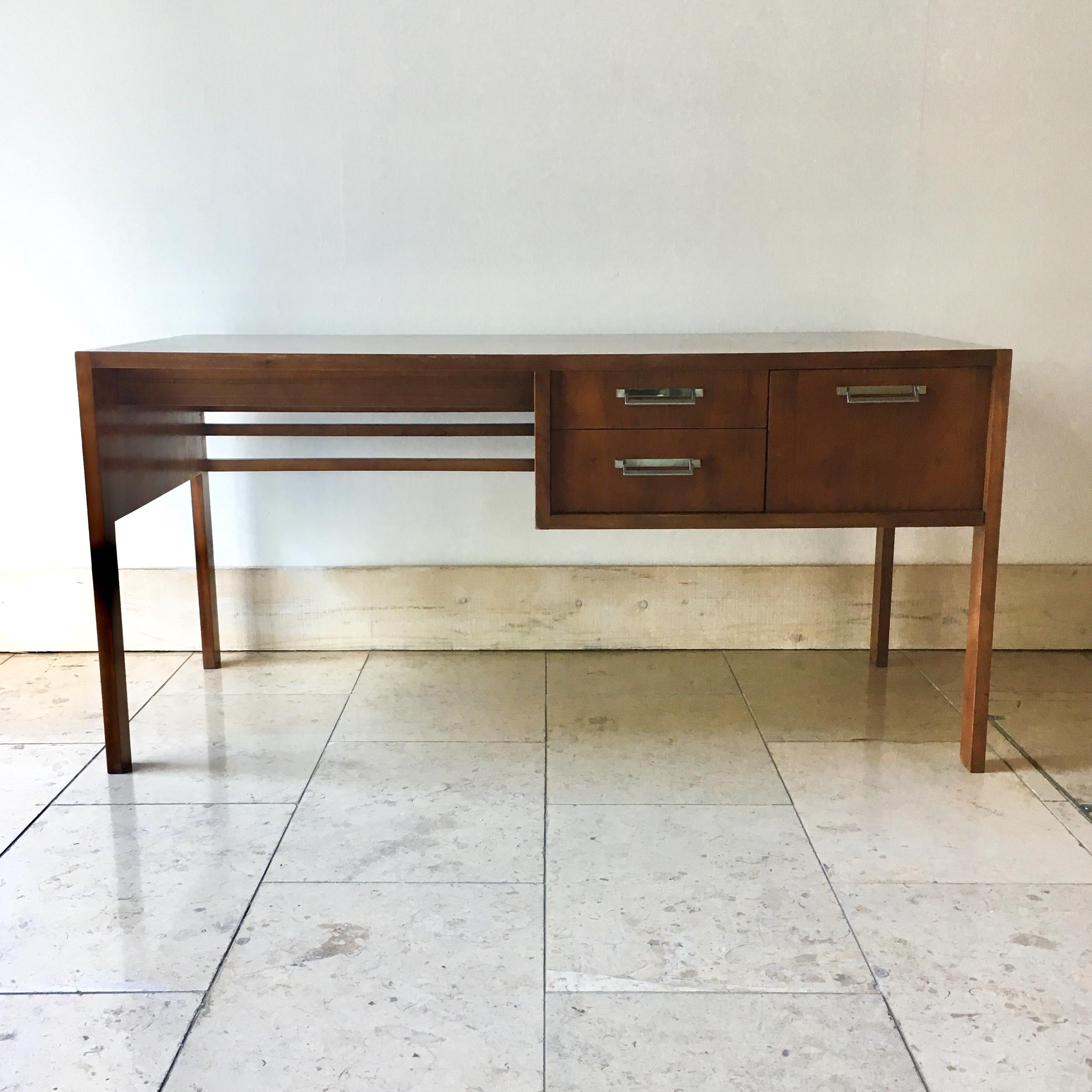 Elegant slim proportioned walnut desk by Baker with nickel handles, stamped interior of drawer with makers mark
Far right hand drawer has angled dividers, all three drawers run smoothly, 1960s.

 Baker was a family business founded by Siebe Baker.