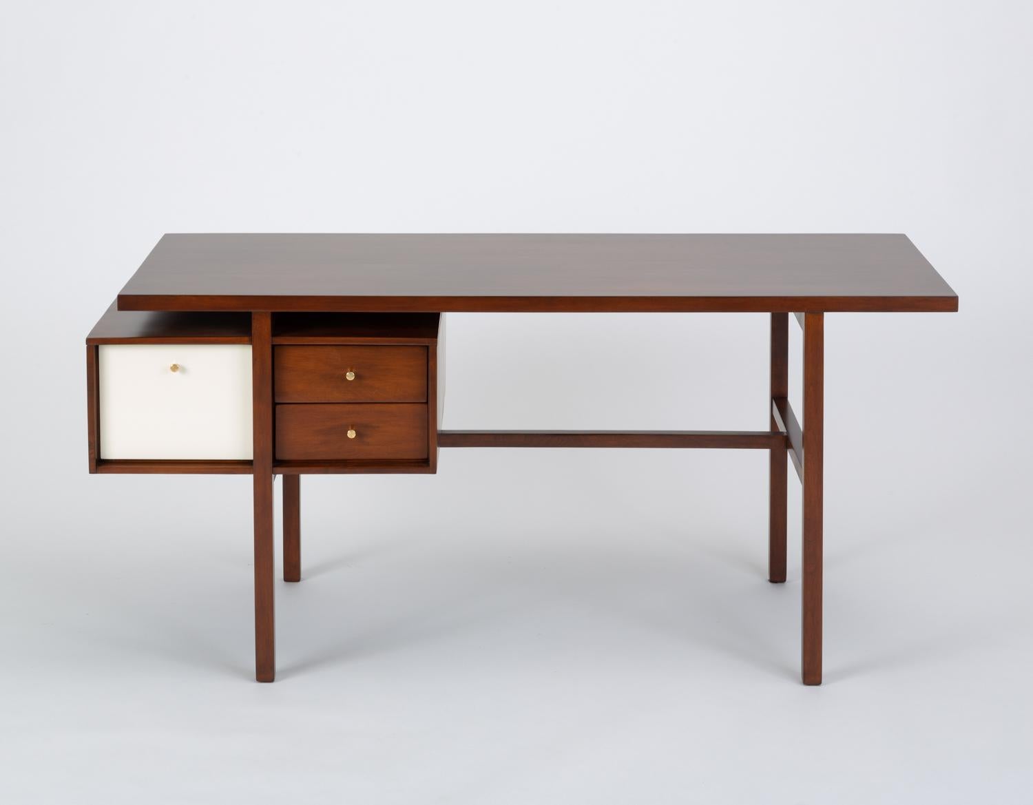 A California design from the early 1950s by Milo Baughman for Glenn of California has a delicate walnut frame in which an offset stack of three drawers appears to float. The deeper of the three drawers has a white laminate panel and all open with