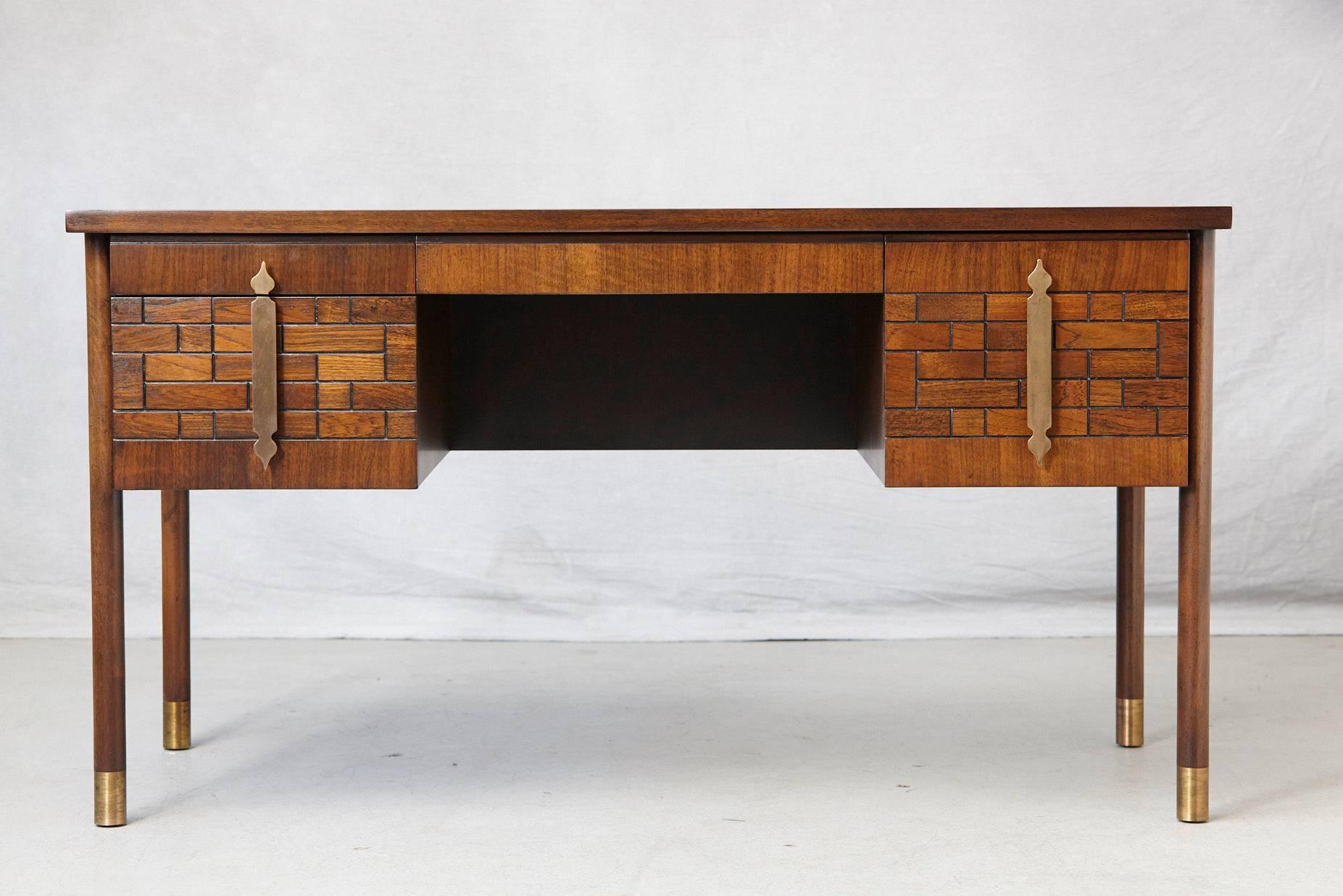 Impressive walnut desk with four drawers, graphic wood work on the drawers, wood inlays on the top and brass hardware, mounted on round legs with brass leg tips. Quality wood construction in excellent condition, circa 1970s.
Height from the floor