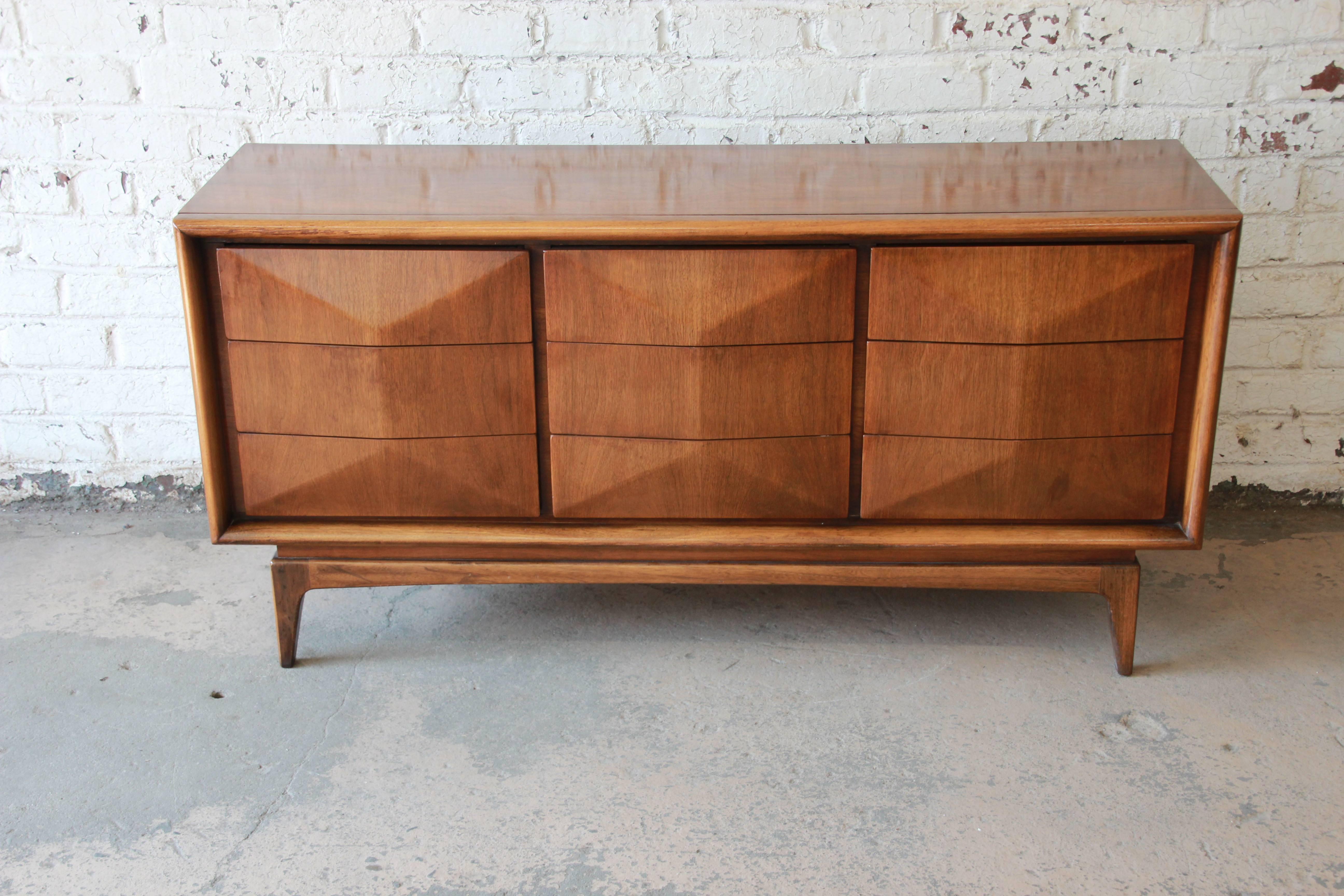 Offering a very nice Mid-Century Modern diamond front nine-drawer dresser by United Furniture Co. Each of the drawers open and close smooth displaying a beautiful walnut wood grain. The dresser is in great vintage condition with very minor surface