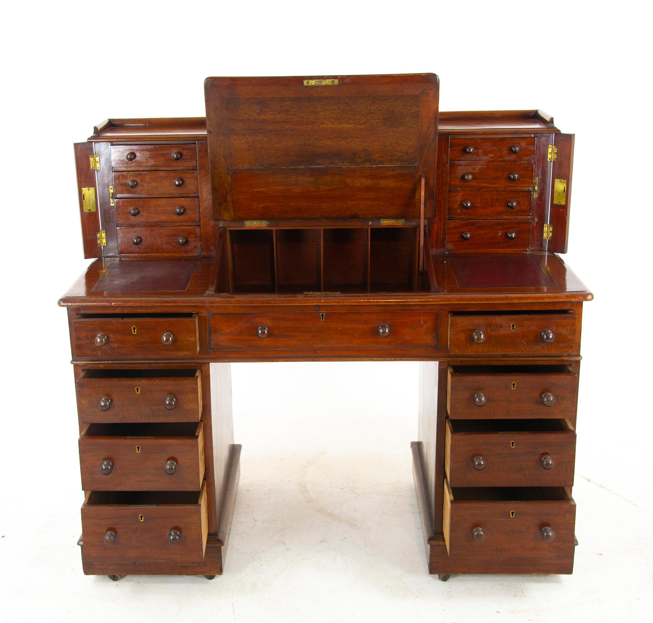 Walnut dickens desk, double pedestal desk, Victorian desk, Scotland 1880, Antique Furniture.

Scotland, 1880.
Top has two sets of four small galleried drawers
Side lockers
Leather writing surface on slanted lid below, raises to reveal storage