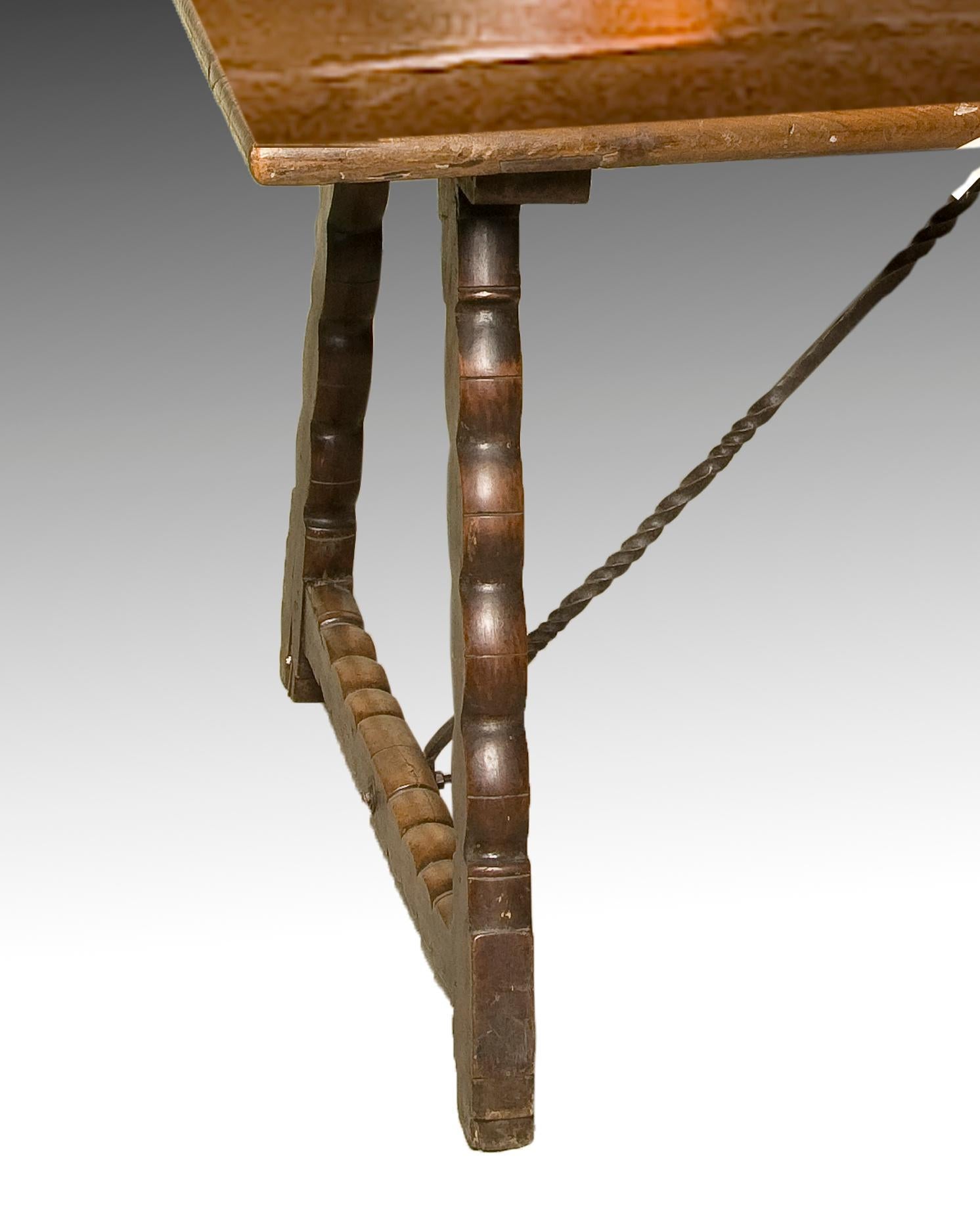 Table de salle à manger en noyer avec attaches en fer forgé. XVIIIe siècle.
Table de salle à manger au plateau rectangulaire et lisse reposant sur des pieds qui suivent, simplifiés, les exemples les plus courants du baroque dit 