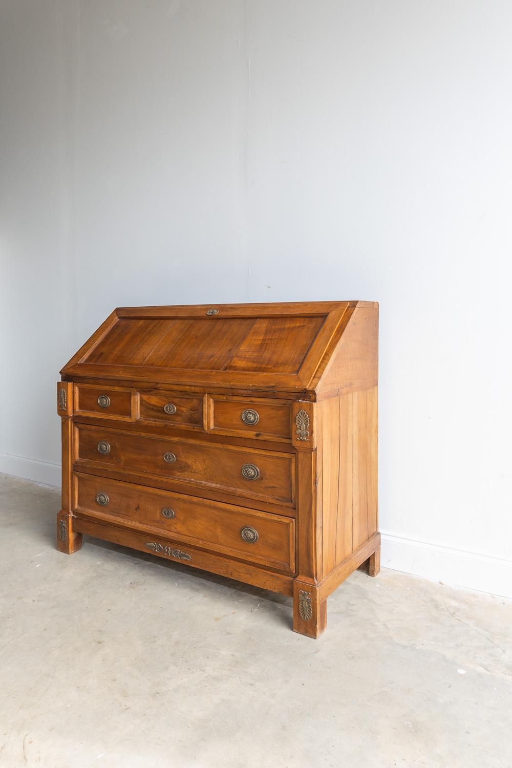 This directory secretary was crafted in 1810, yet the condition of this desk seems practically new. The dark wood color is a beautiful stained walnut. There are two big lower drawers and three smaller central drawers. When you open the cabinet,