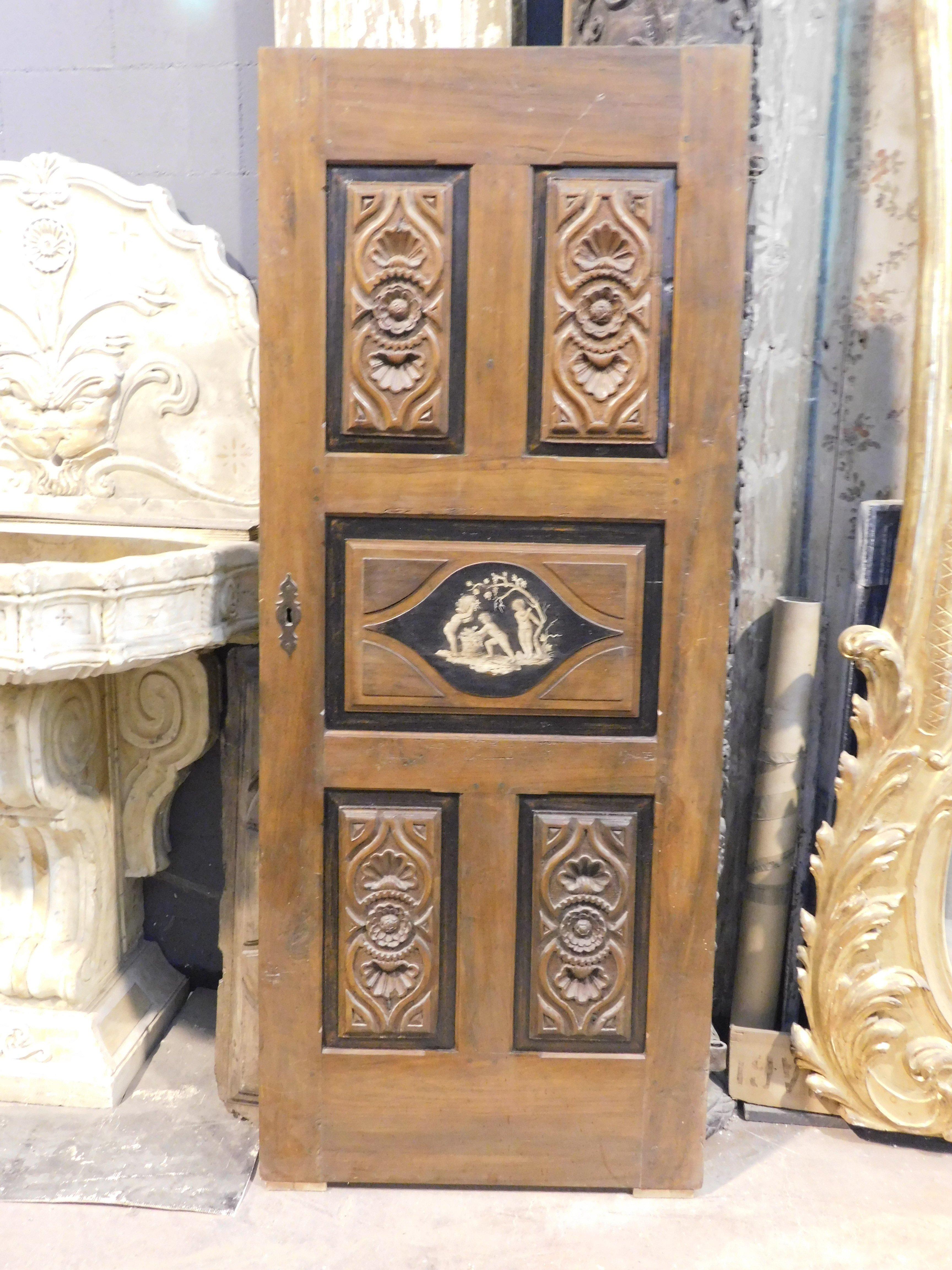Puerta antigua de madera de nogal preciosa y maciza, puerta interior, ricamente tallada y también pintada en los paneles, Paneles tallados con decoraciones florales con pintura central que representa querubines. original del siglo XVIII, originaria