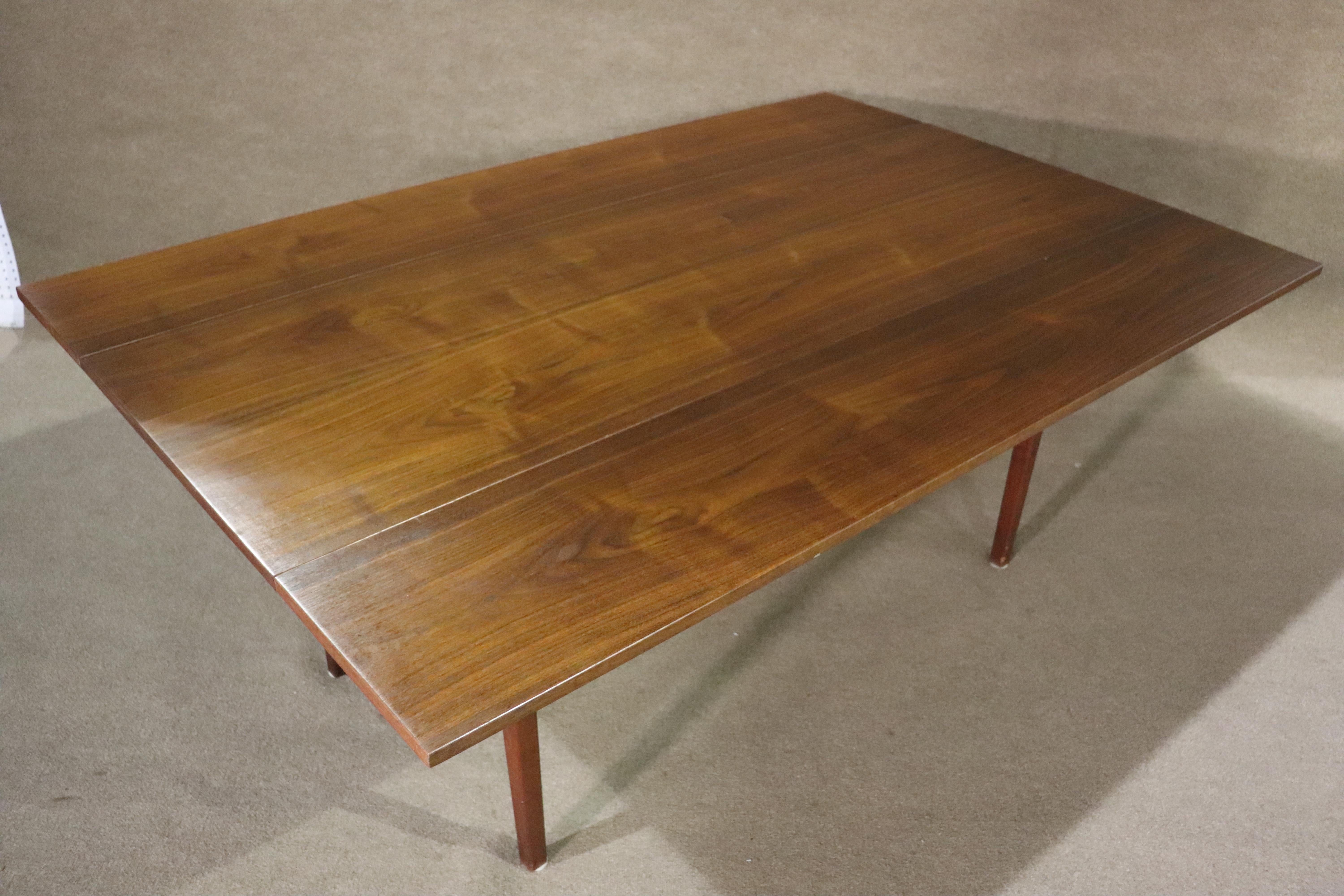 Long mid-century table with two 12 inch leaves that fold down to convert to a entry or sofa console. Warm walnut grain throughout with slim tapered legs.
Please confirm location NY or NJ