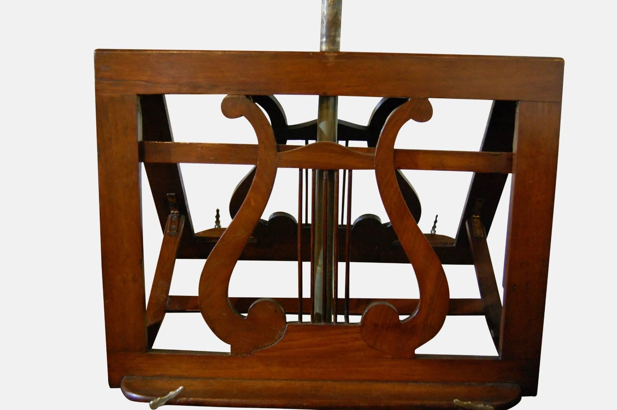 Mid-Victorian walnut adjustable duet music stand on carved tripod base.

Depth measured at fully extended point.