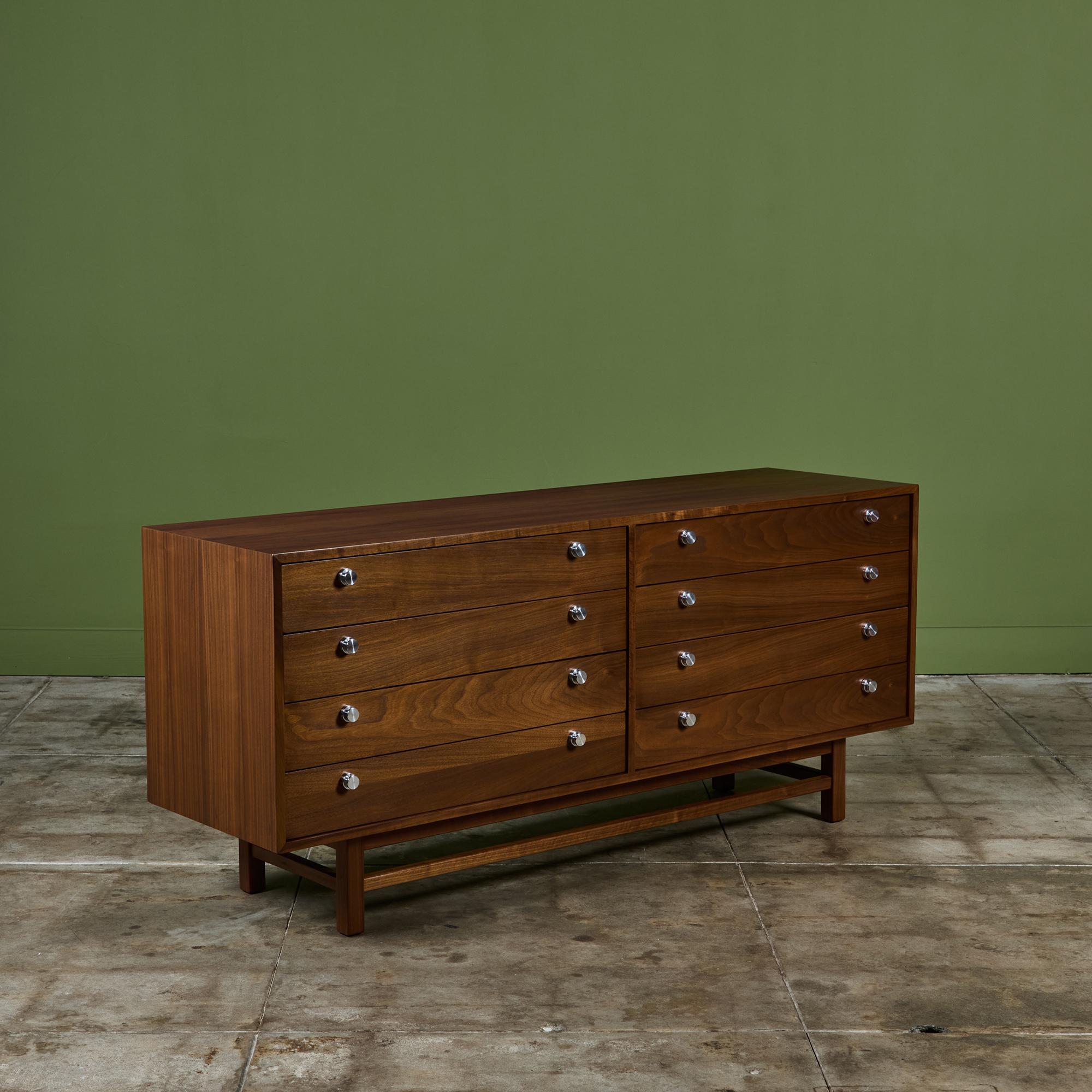 Walnut dresser features eight drawers with round aluminum drawer pulls. The cabinet is supported by four walnut legs and stretchers.

Dimensions
68