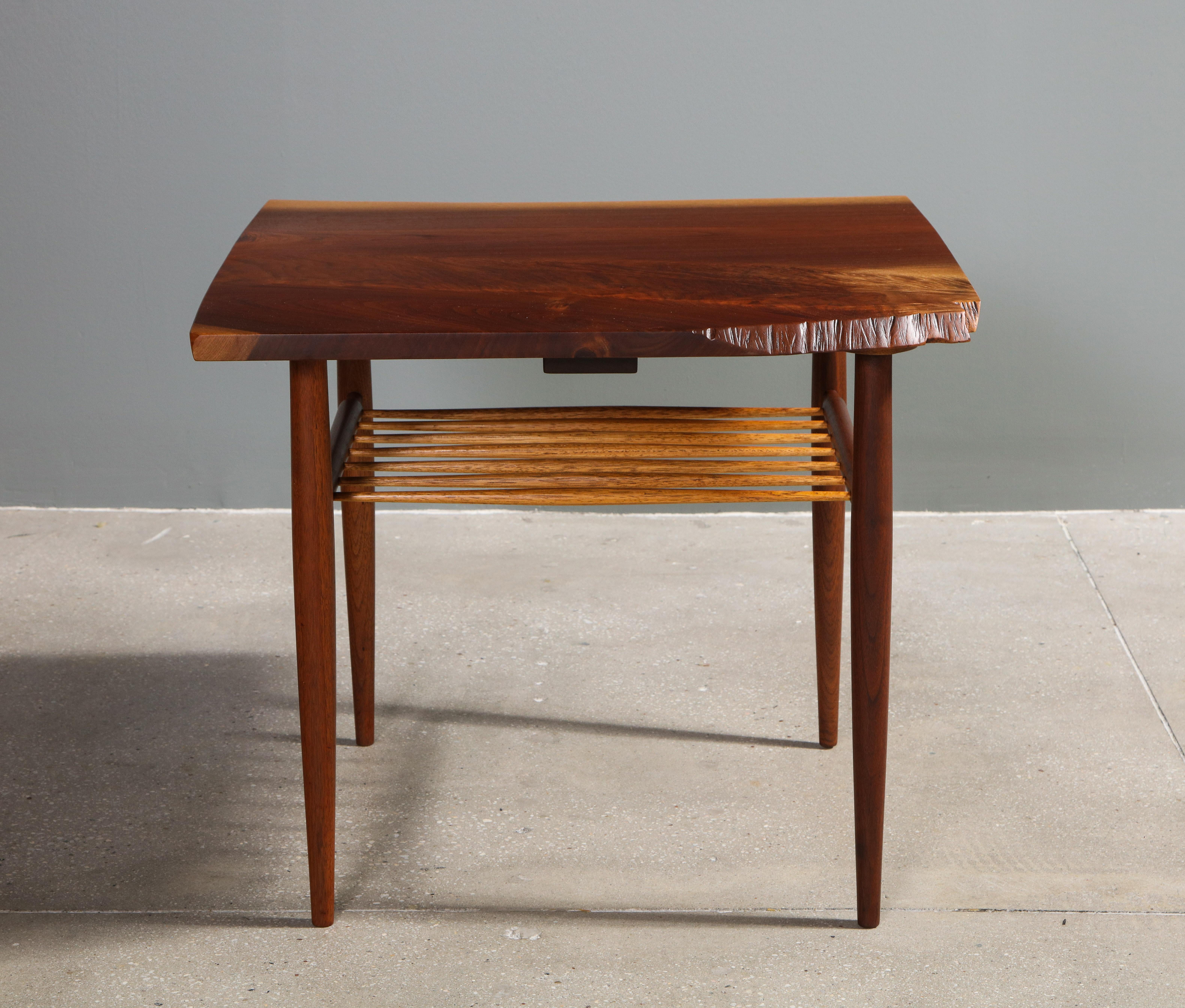 An early side table made from a free-edged walnut plank with four spindle legs and eight spindles as a shelf in 1960, by George Nakashima. 

Recently restored by Nakashima Studios.

Provenance includes all original purchase receipts and letter