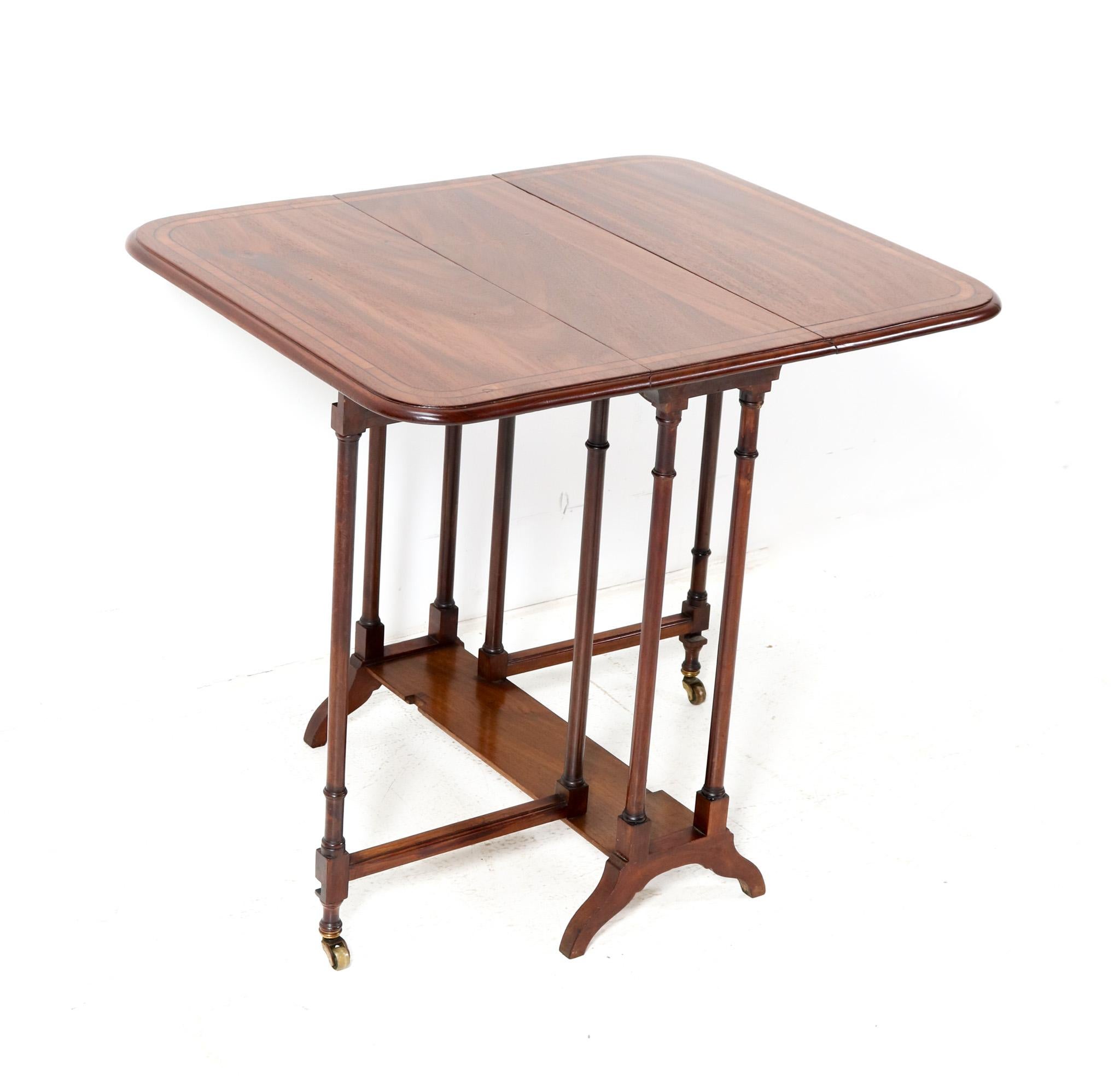 Stunning and elegant English 19th Century spider leg table with drop leaves.
Striking English design from the 1860s.
Solid walnut base with original solid walnut and inlay top.
The whole riding smoothly upon a set of six original brass castors.
This