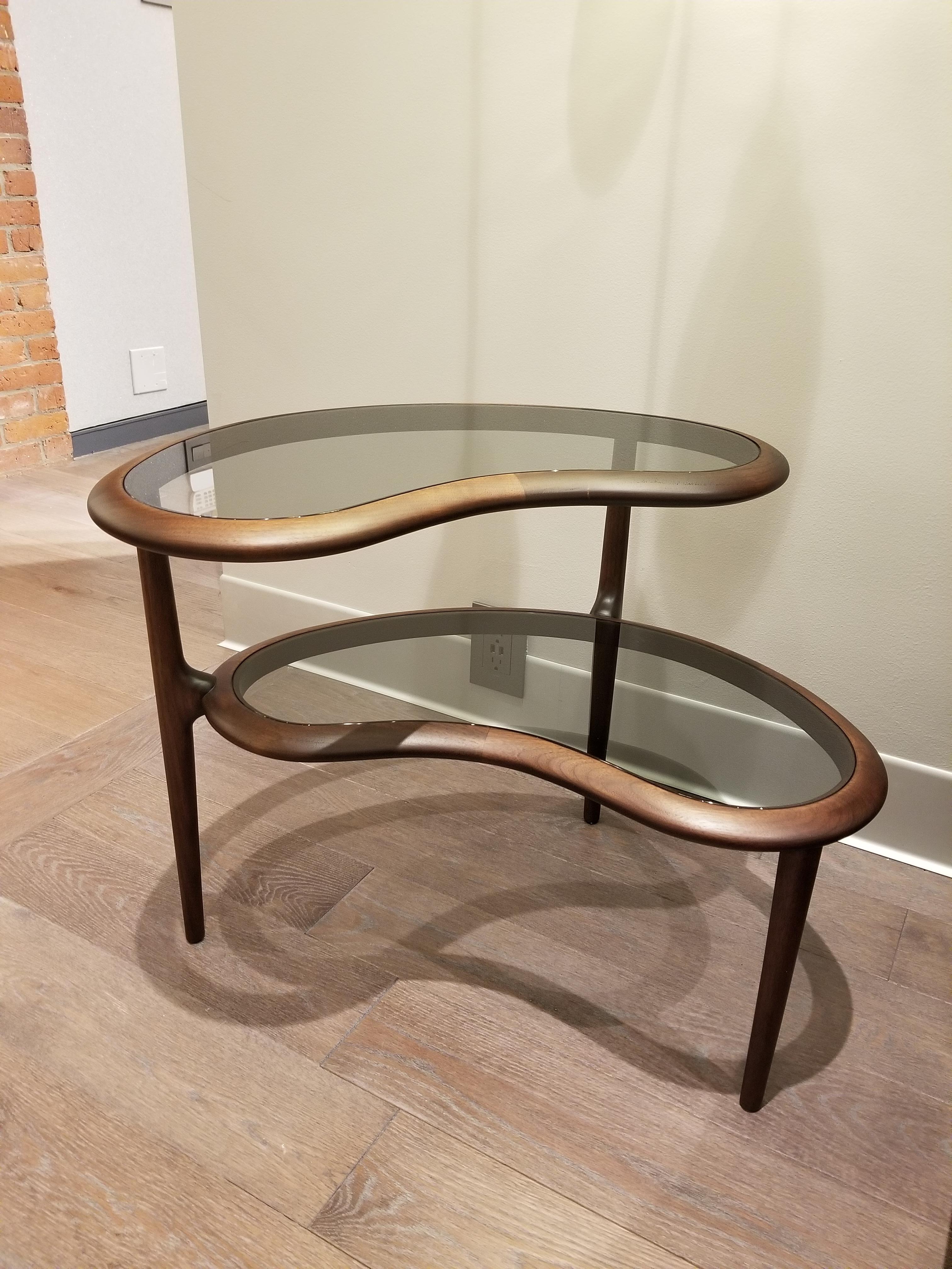 Fagiolo is the coffee table signed by Roberto Lazzeroni for Ceccotti Collections double soul and the organic form inspired by the famous legume whose name it bears.

Table left handmade in solid dark american walnut, double top in smoked