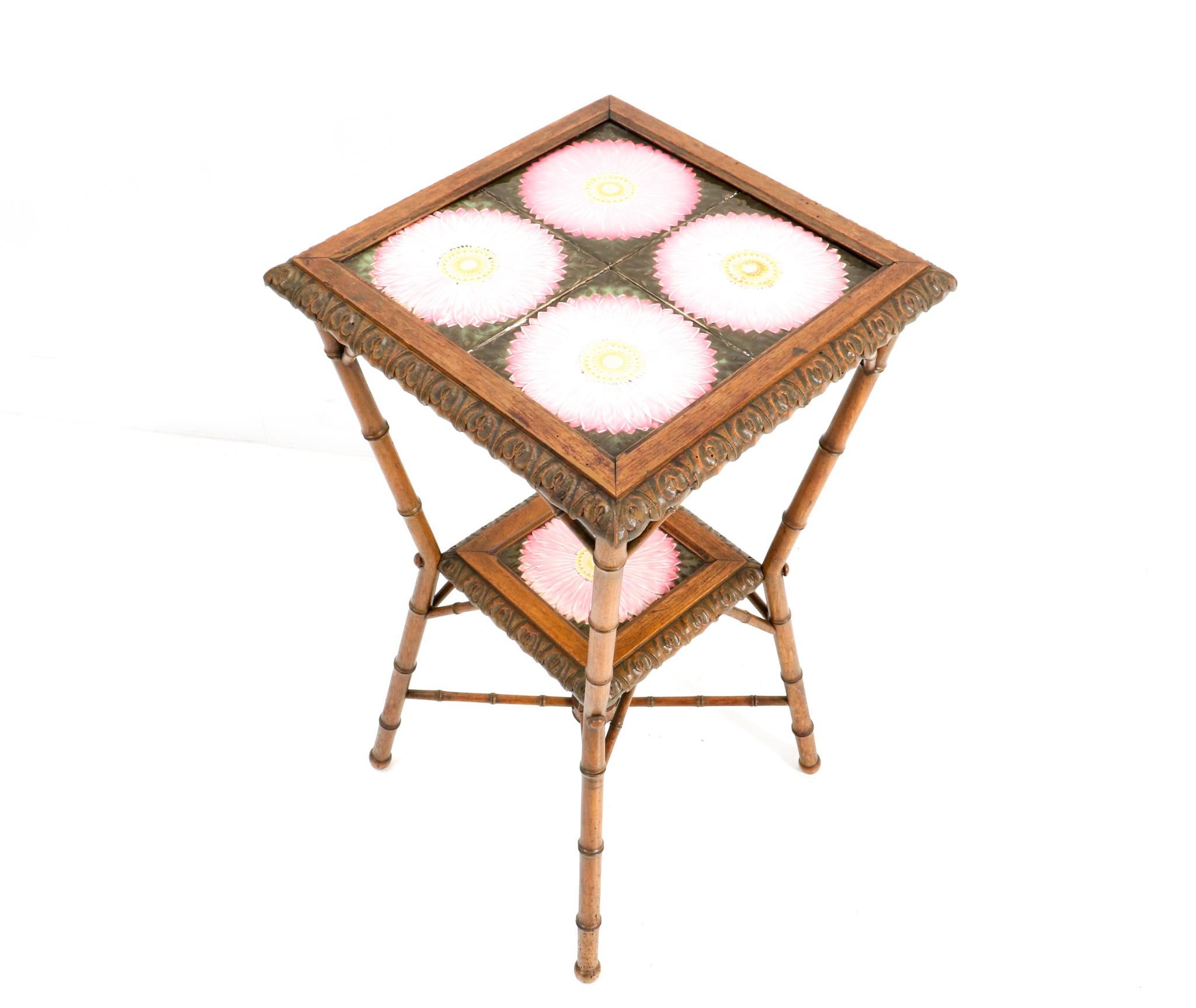 Stunning and rare Art Nouveau side table or plant stand.
Striking French design from the 1900s.
Solid walnut faux bamboo base with original multi-colored tiles in top and bottom.
This wonderful Art Nouveau side table or plant stand is in good