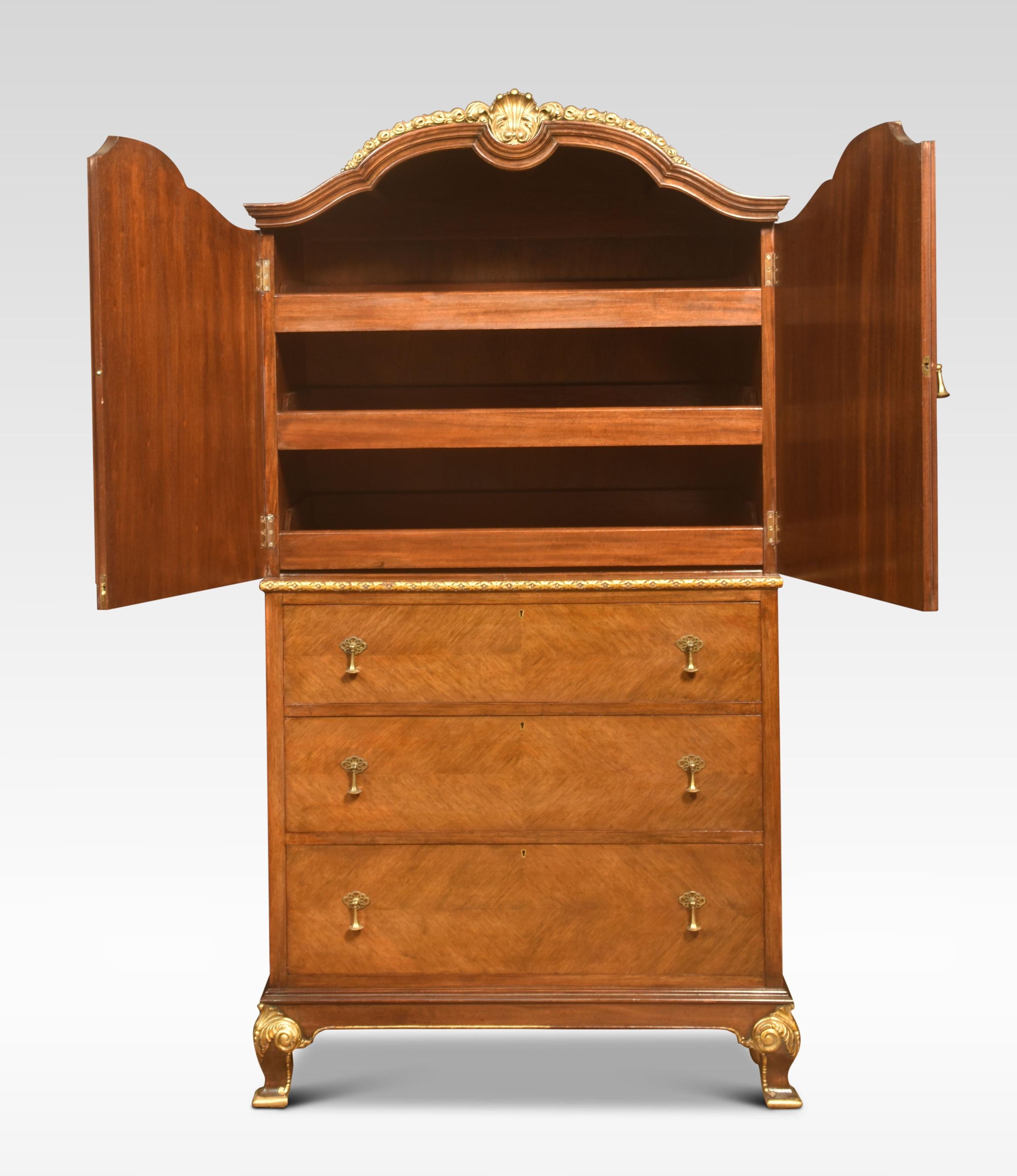 Walnut figured cabinet, the shaped top with central carved gilded shell above a pair of panelled doors, opening to reveal three sliding trays, To the base section having three long graduated drawers. All raised up on shaped feet.
Dimensions
Height