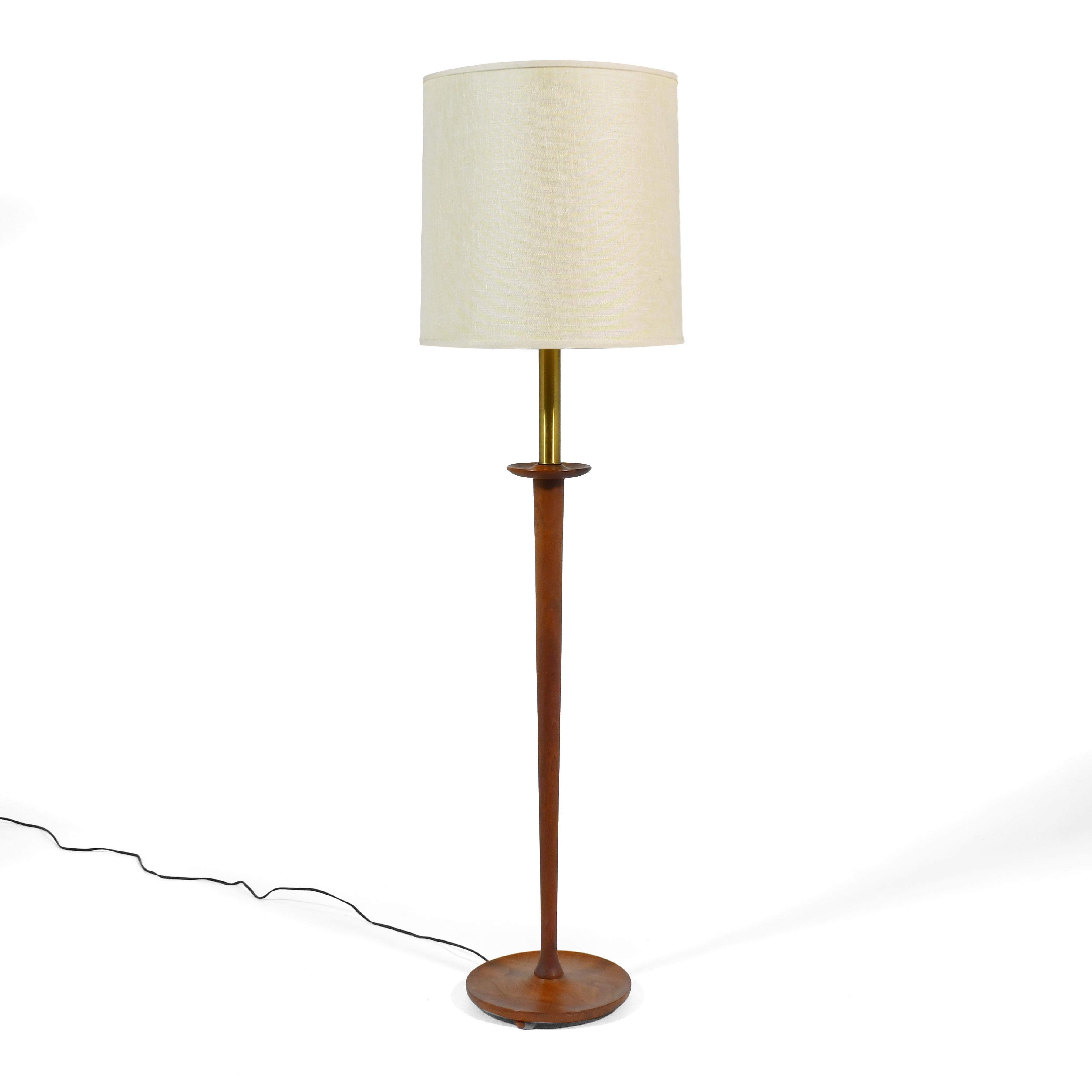 The appeal of this lamp lies in the beautifully sculpted details of its solid walnut base. The neck is cylindrical brass which meets the walnut which has a tapered column with lovely subtle curves where it meets the neck and base. Three recessed