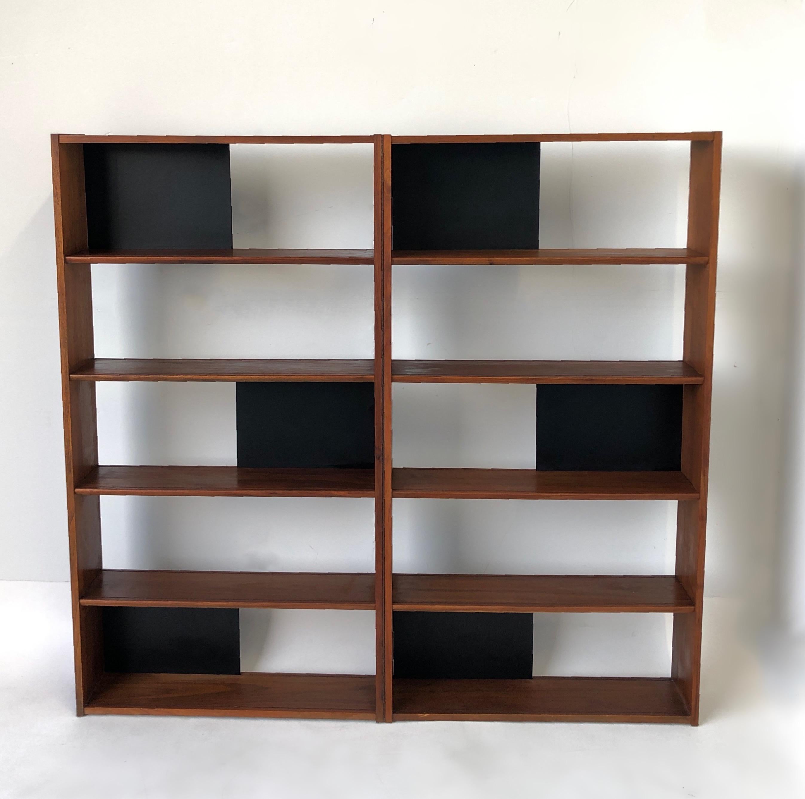 1950’s Walnut folding bookcase or room divider, designed by Evans Clark for Glenn of California. 
Constructed of walnut vernier and black lacquered sliding panels. It can be used open or closed. 
In original vintage condition, shows minor wear