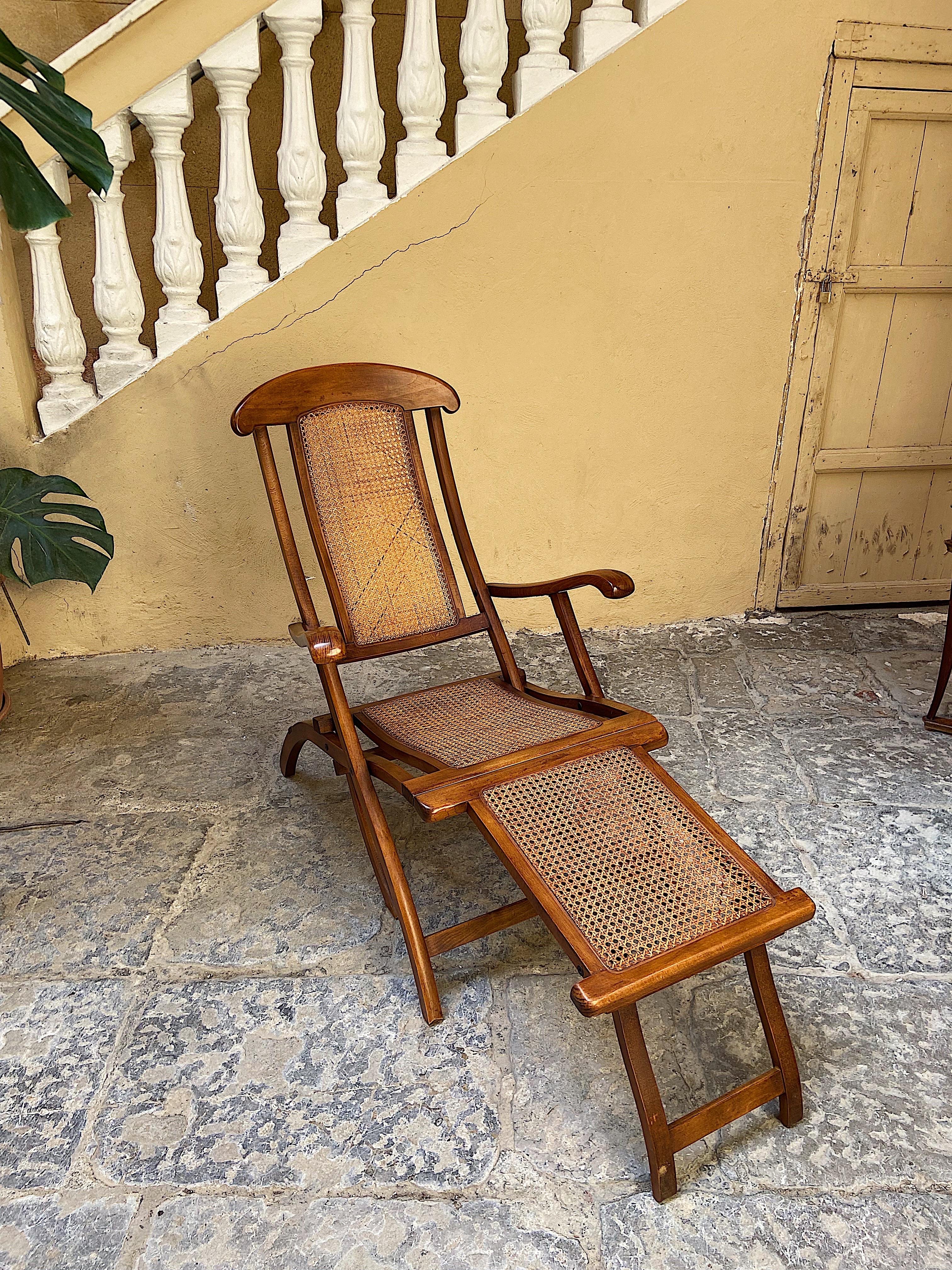 Elegant walnut framed folding steamer deck chair. The shape of this chair is more than elegant. Its very comfortable. This was first designed in the 1930s but this version was made 1970. Framed in walnut with cane work on back and seat. Soft shaped