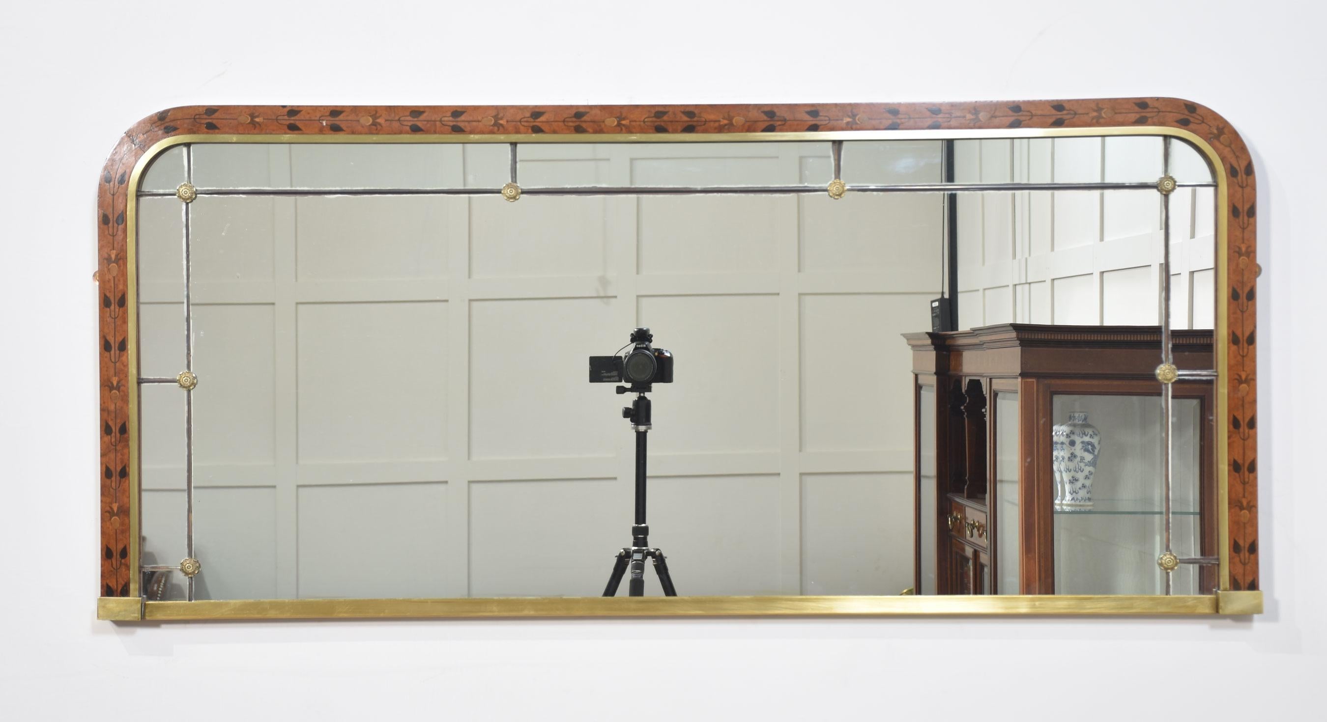 Walnut-framed overmantel mirror, the inlaid frame surrounding the original segmented mirror plate applied with brass detail.
Dimensions
Height 23.5 Inches
Width 52.5 Inches
Depth 1.5 Inches