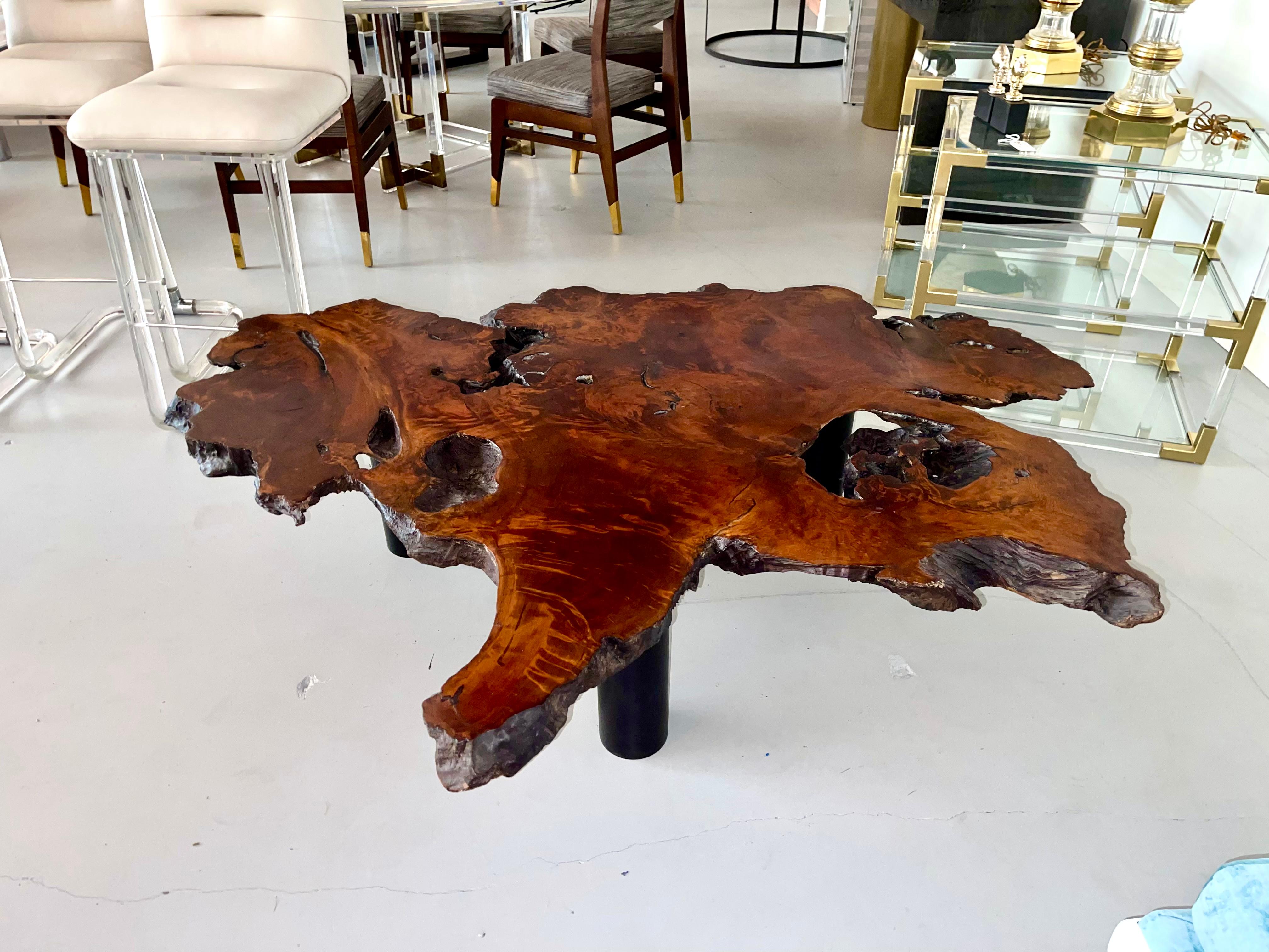 A vintage massive walnut slab from the 1970's. We had the top stripped of the heavy epoxy resin finish and had a new base fashioned of three steel legs painted a flat black. Great organic form and wonderful graining. Natural void ares on the top