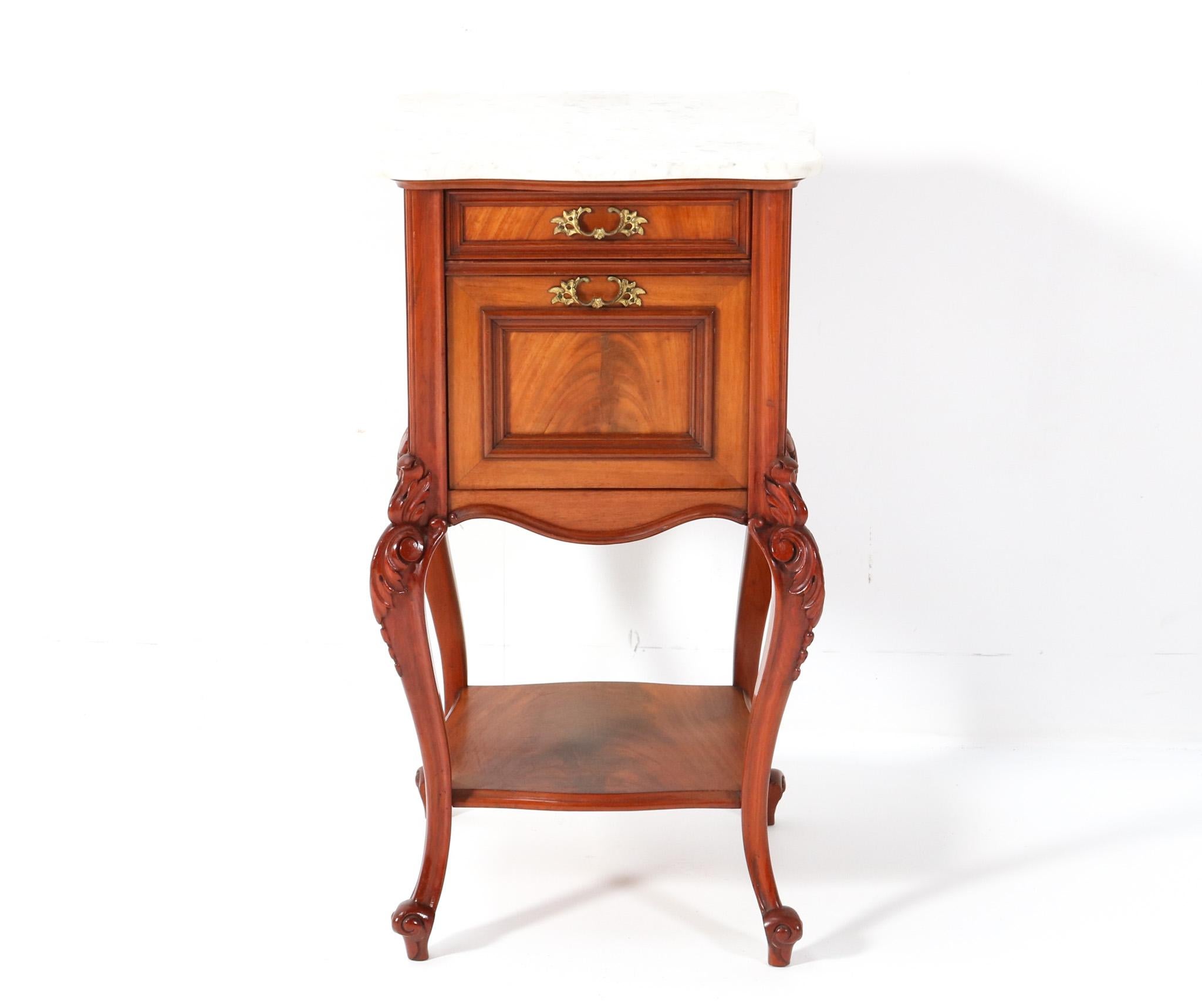 Stunning and rare Louis XV style nightstand or bedside table.
Striking French design from the 1900s.
Solid walnut base with original bronze handles on door and drawer.
Original curved white marble top.
This wonderful Louis XV style nightstand or