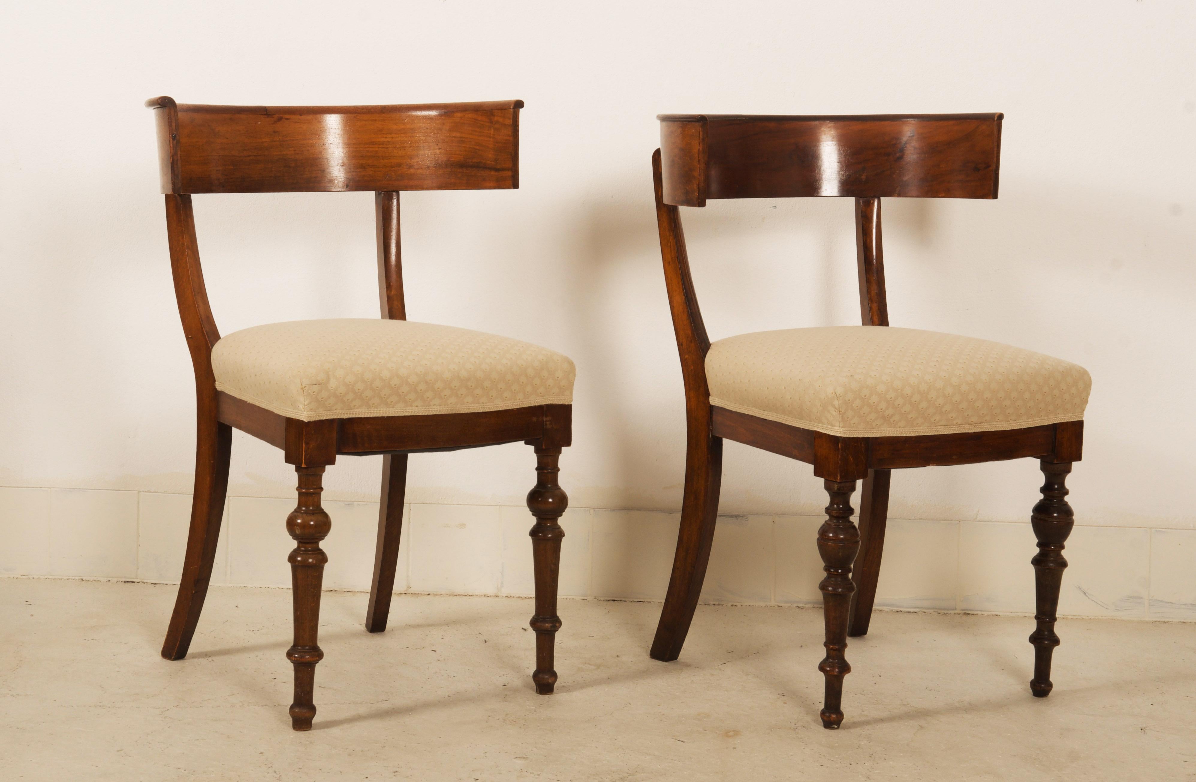 A pair of late 19th century walnut Klismos chairs with turned front legs (each different), splayed back legs and curved backrests. Made in England in the 1880s.